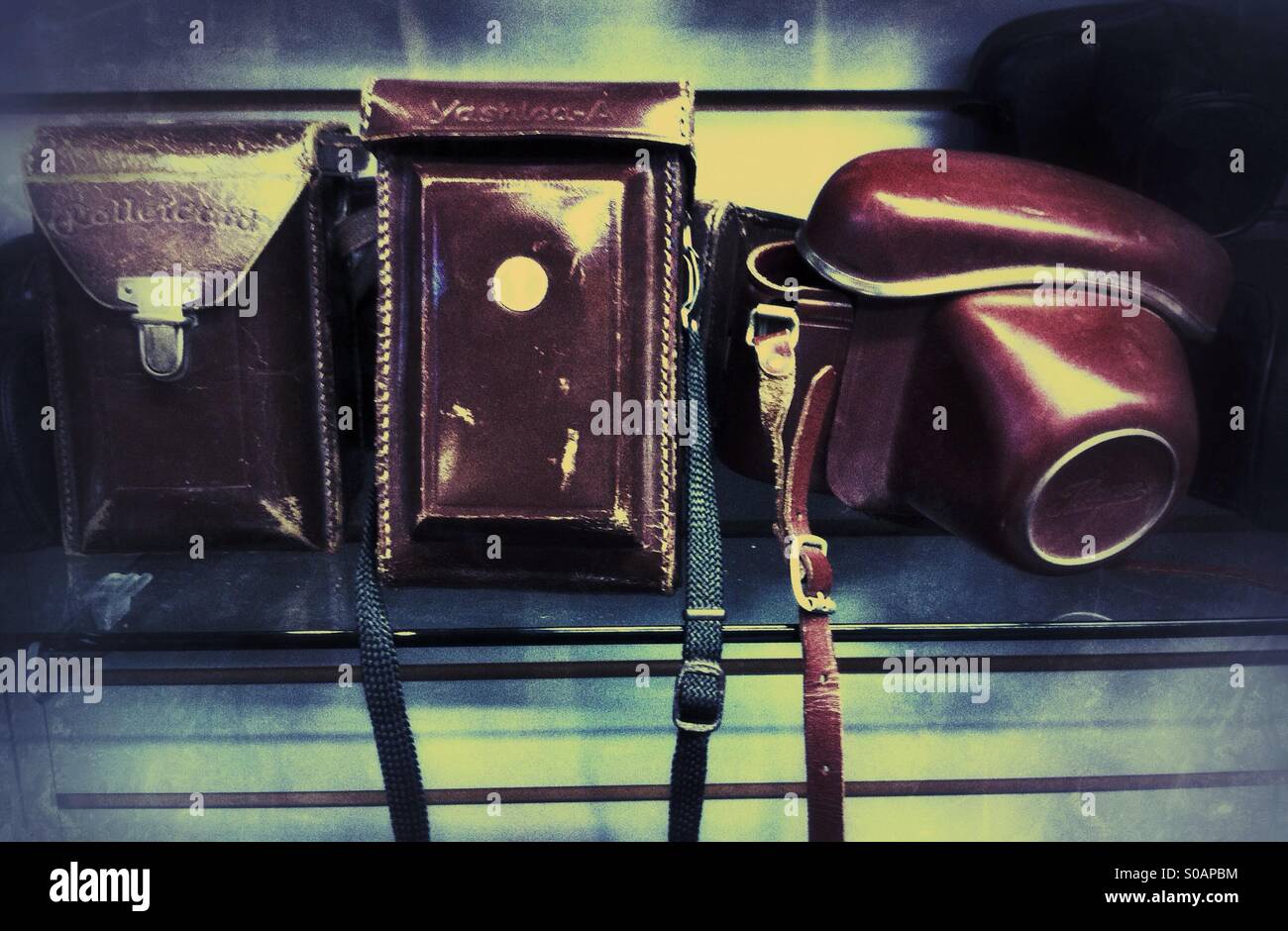 Alte Leder-Kameratasche auf einem Regal - Smartphone-aufgenommenes Stockfoto