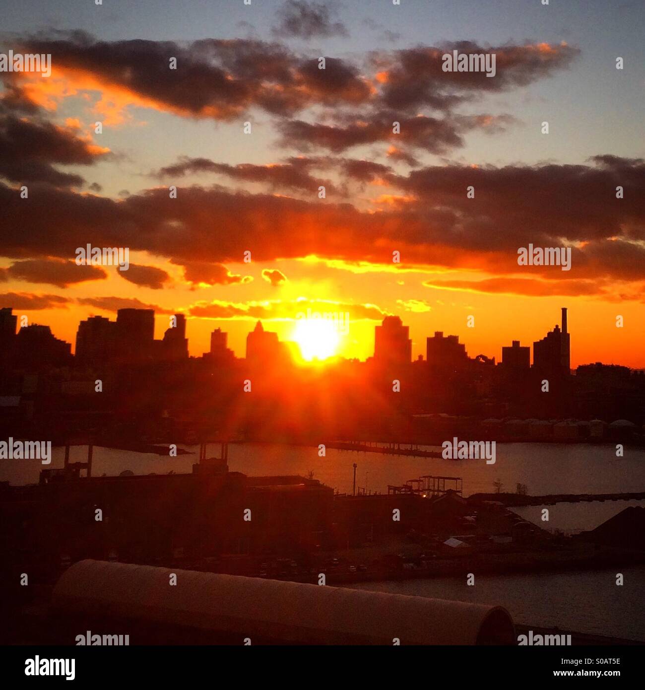 Sonnenuntergang über dem East River, New York und Brooklyn Navy Yard. Stockfoto