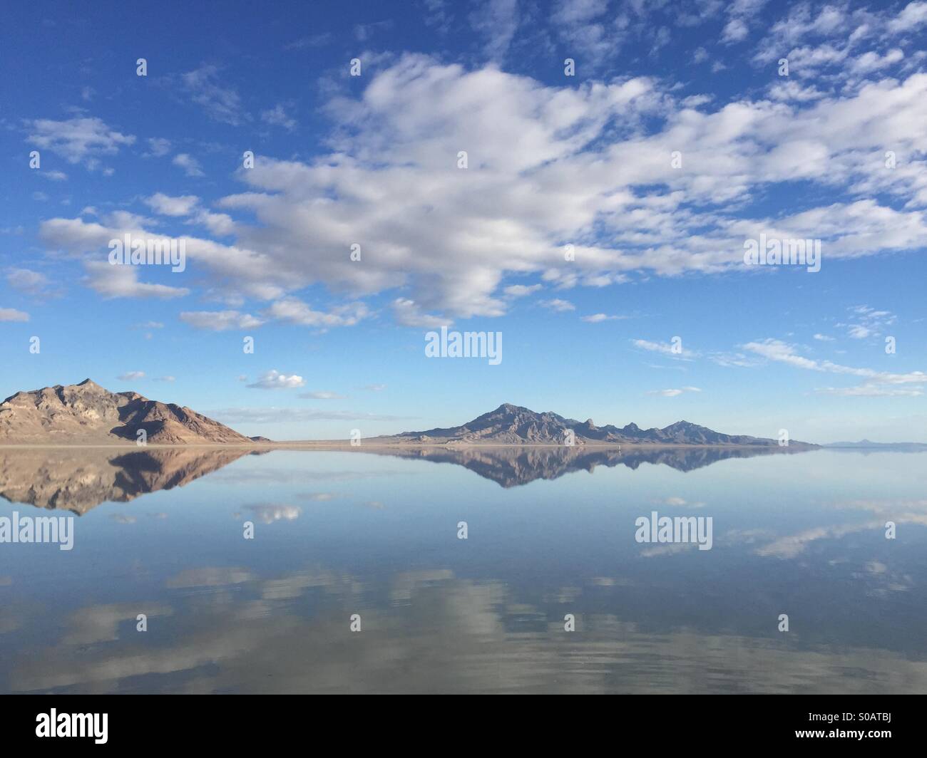Auf den Bonneville Salt Flats in Utah gesammelte Wasser Erstellen einer schillernde Reflektion auf die umliegenden Berge. Stockfoto