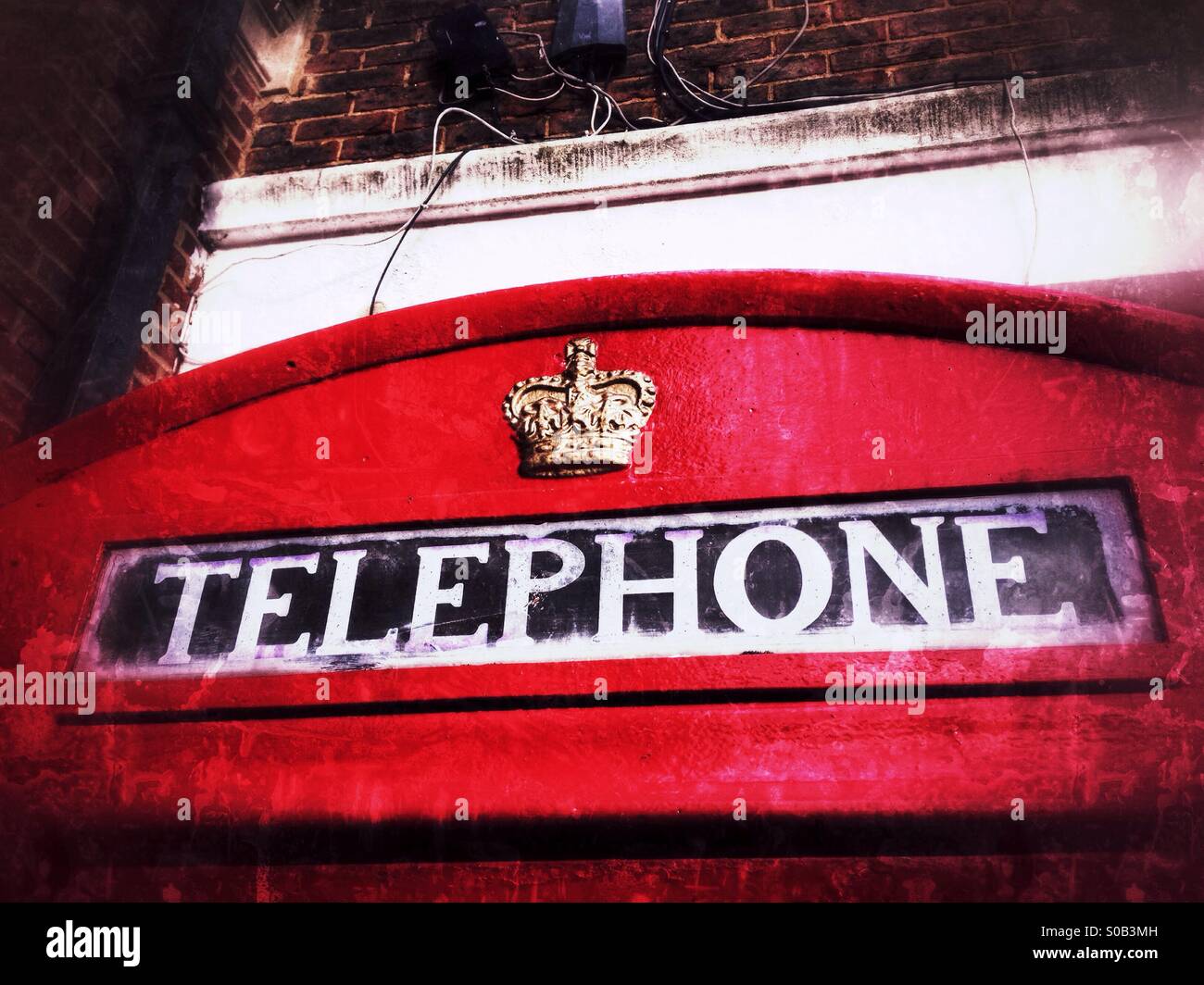 Krone & Zeichen auf eine traditionelle britische Telefonzelle. Guildford, Surrey, England. - Smartphone-aufgenommenes Stockfoto