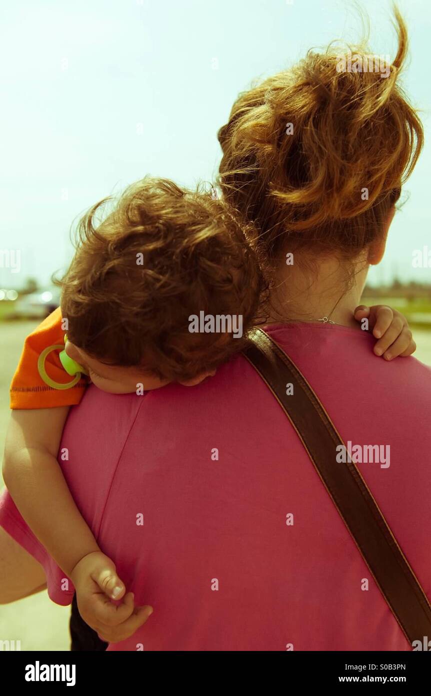 Kleinkind Jungen schlafend auf Mutters Schulter, von hinten Stockfoto
