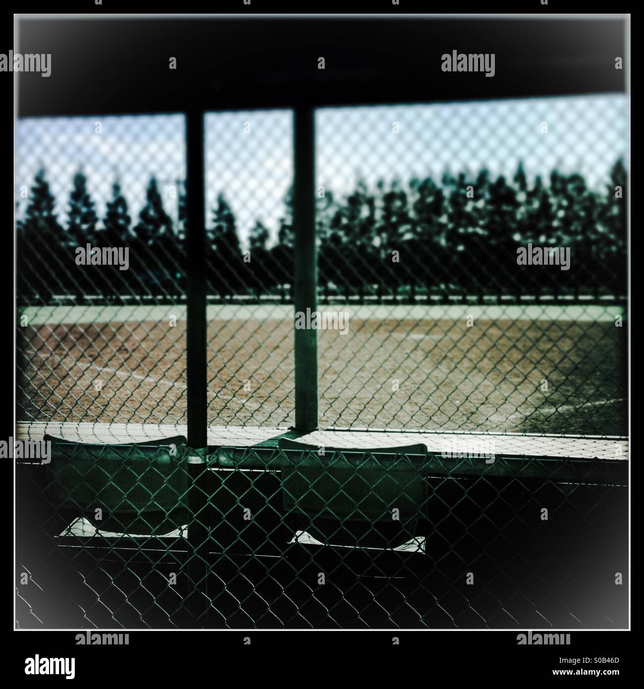 Zwei leere Stühle hinter Hauptplatte auf eine leere Baseball-Feld. - Smartphone-aufgenommenes Stockfoto