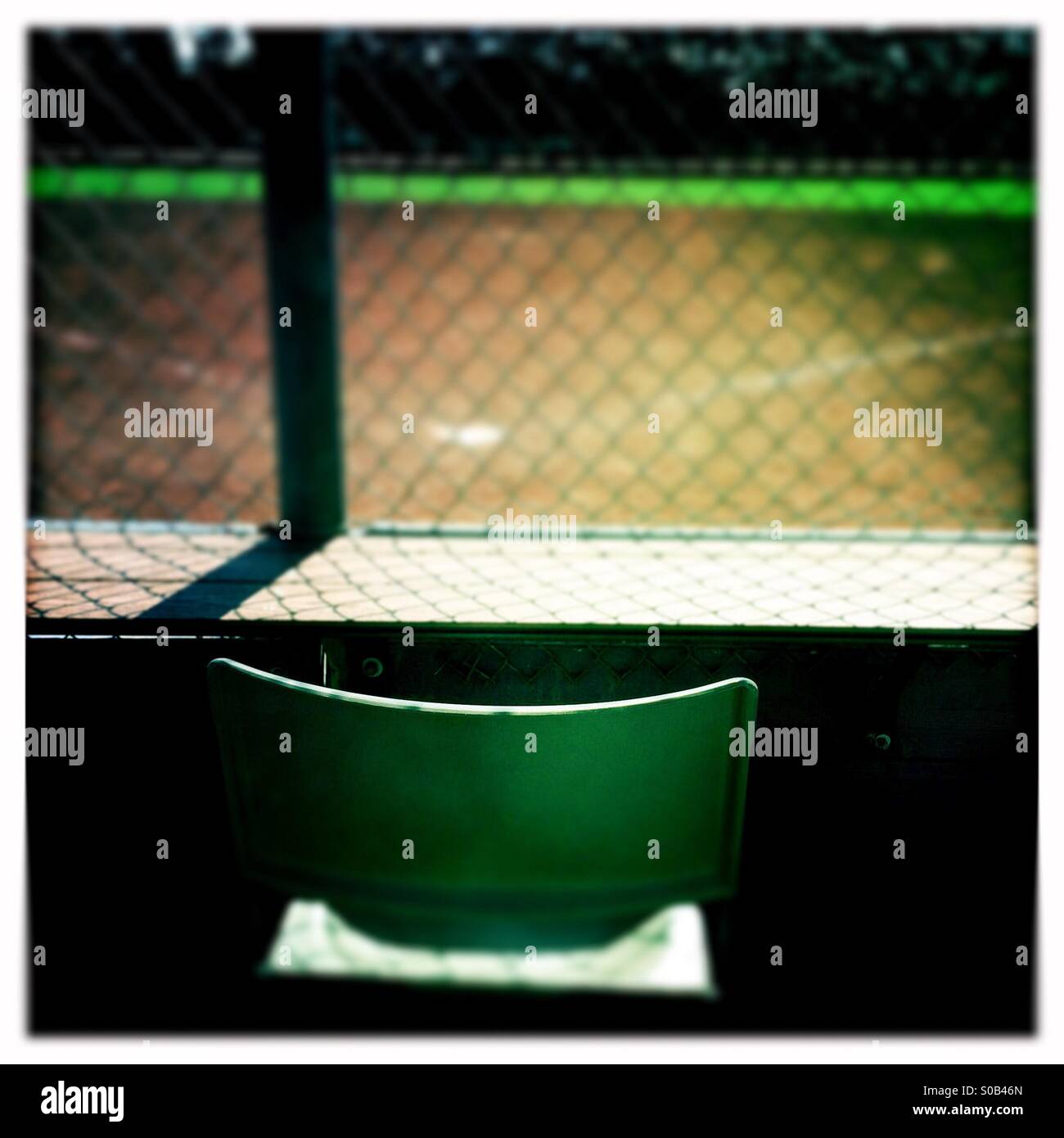 Einen leeren Stuhl hinter Hauptplatte auf eine leere Baseball-Feld. - Smartphone-aufgenommenes Stockfoto