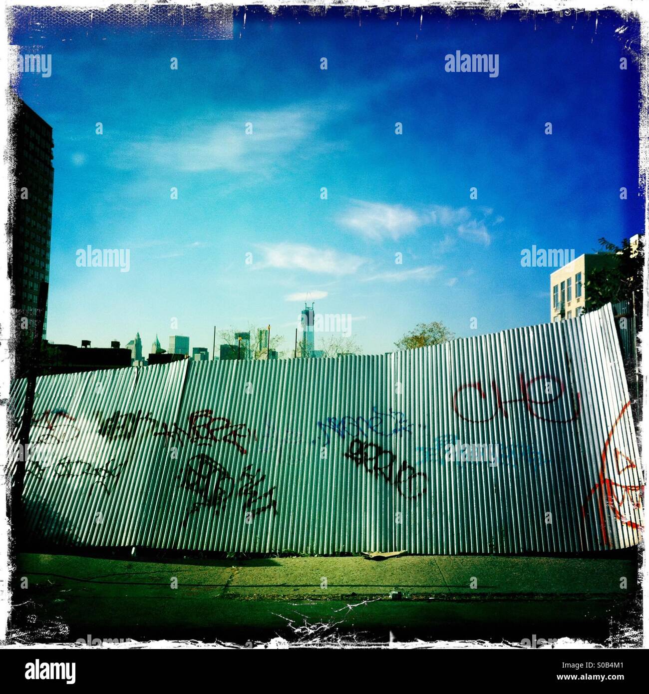 Gewellte Metall-Zaun in Williamsburg, Brooklyn, mit Blick auf Freedom Tower. Stockfoto