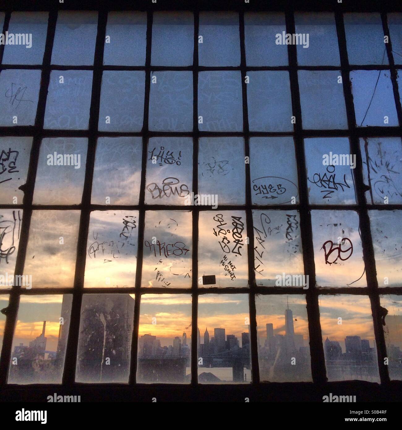 Großes Fenster von Loft-Gebäude mit Blick auf Manhattan bei Sonnenuntergang Stockfoto