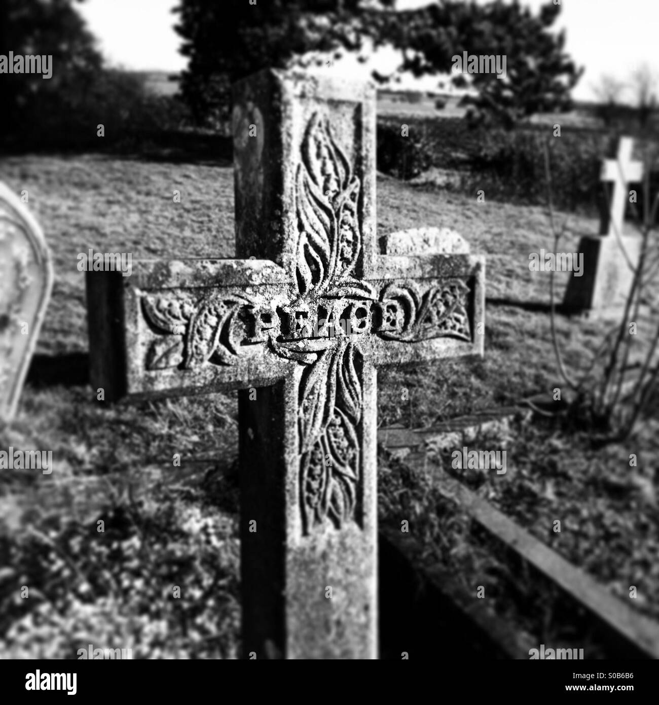Kruzifix Grabstein mit dem Wort Frieden in sie geschnitzt. Stockfoto