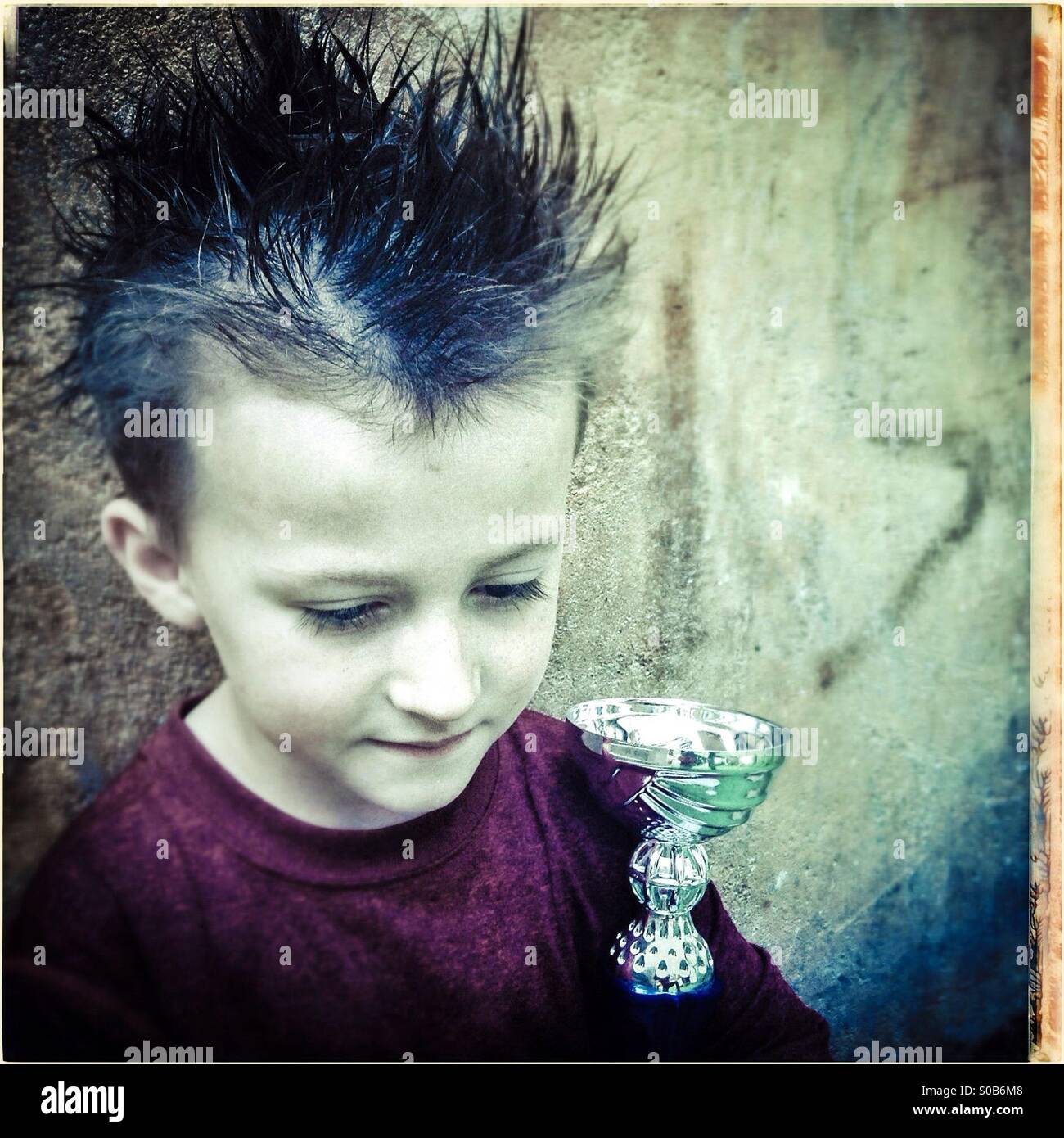 Junge Gedanken über seine Trophäe - Smartphone-aufgenommenes Stockfoto