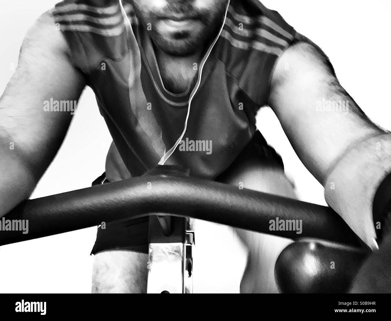 Ein Kerl in der Turnhalle auf einem stationären Fahrrad Stockfoto