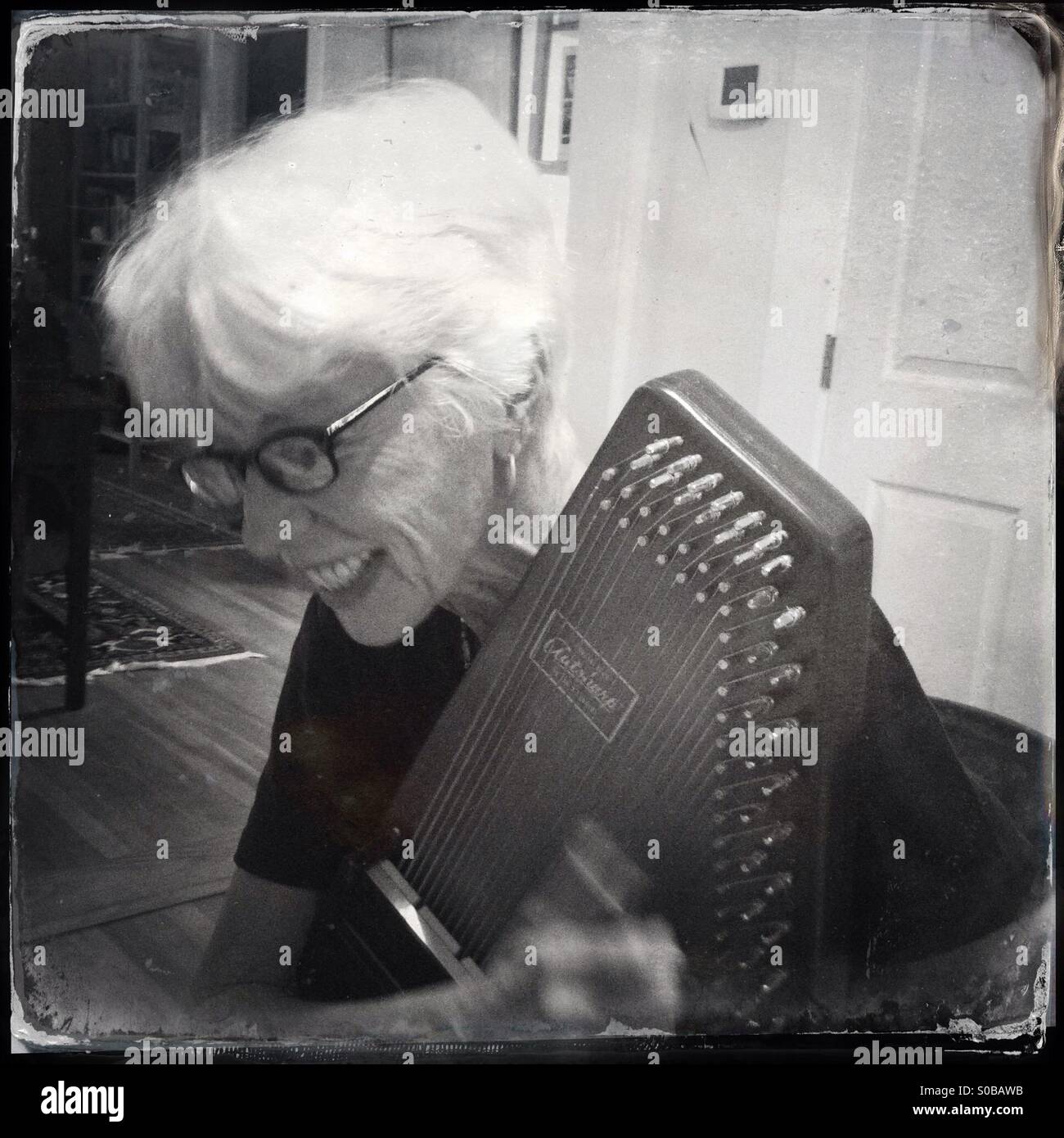 Ältere Frau Autoharp spielen. Stockfoto
