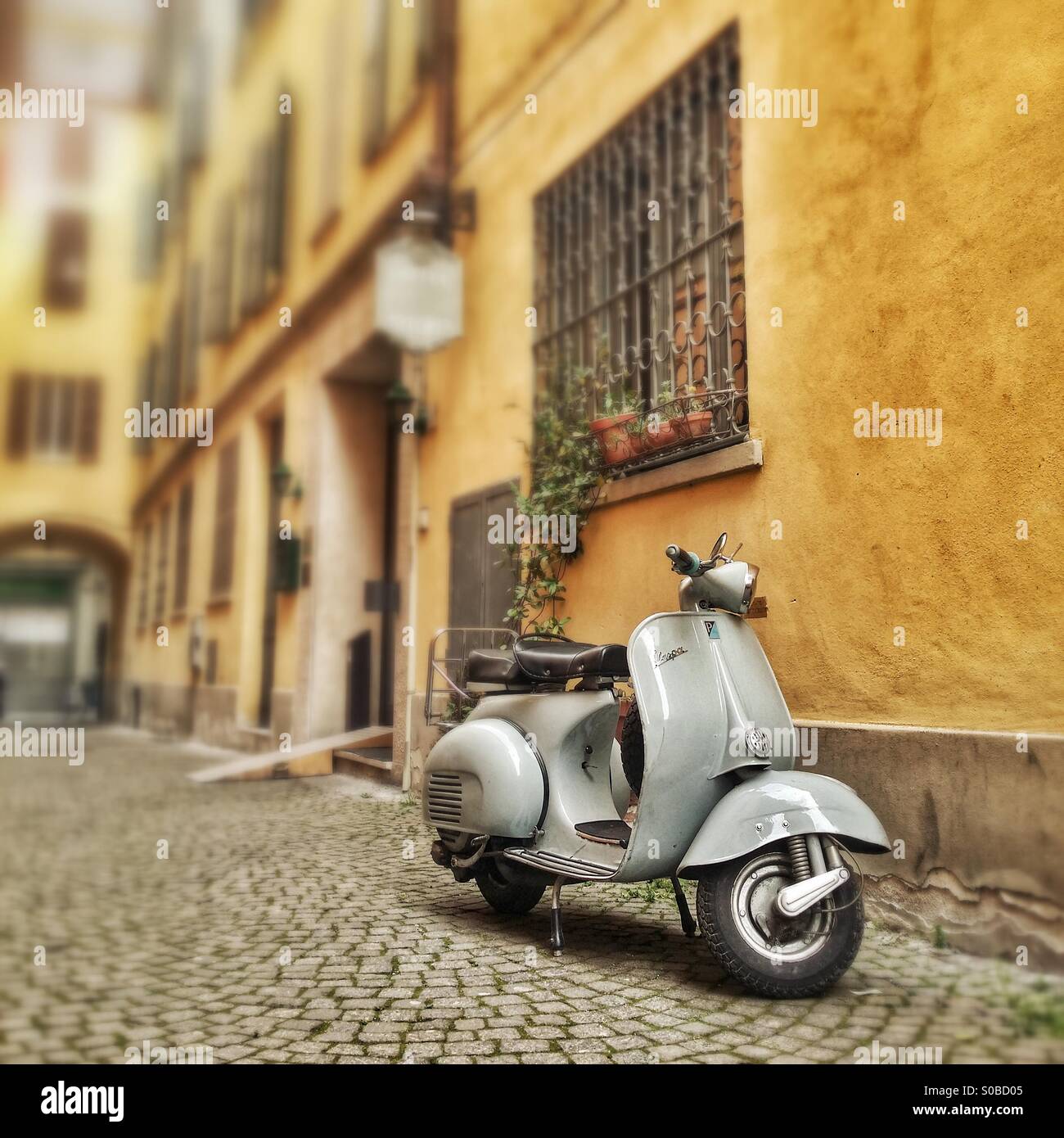 Eine Vespa geparkt in einer Gasse in der Mitte einer alten italienischen Stadt - Smartphone-aufgenommenes Stockfoto