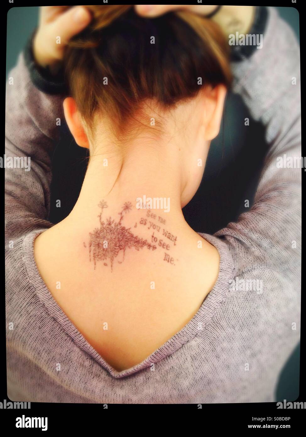 Ein Mädchen mit einer Zeichnung auf der Rückseite der Hals und die Worte "Sie sehen mich, wie Sie mich sehen wollen." Stockfoto