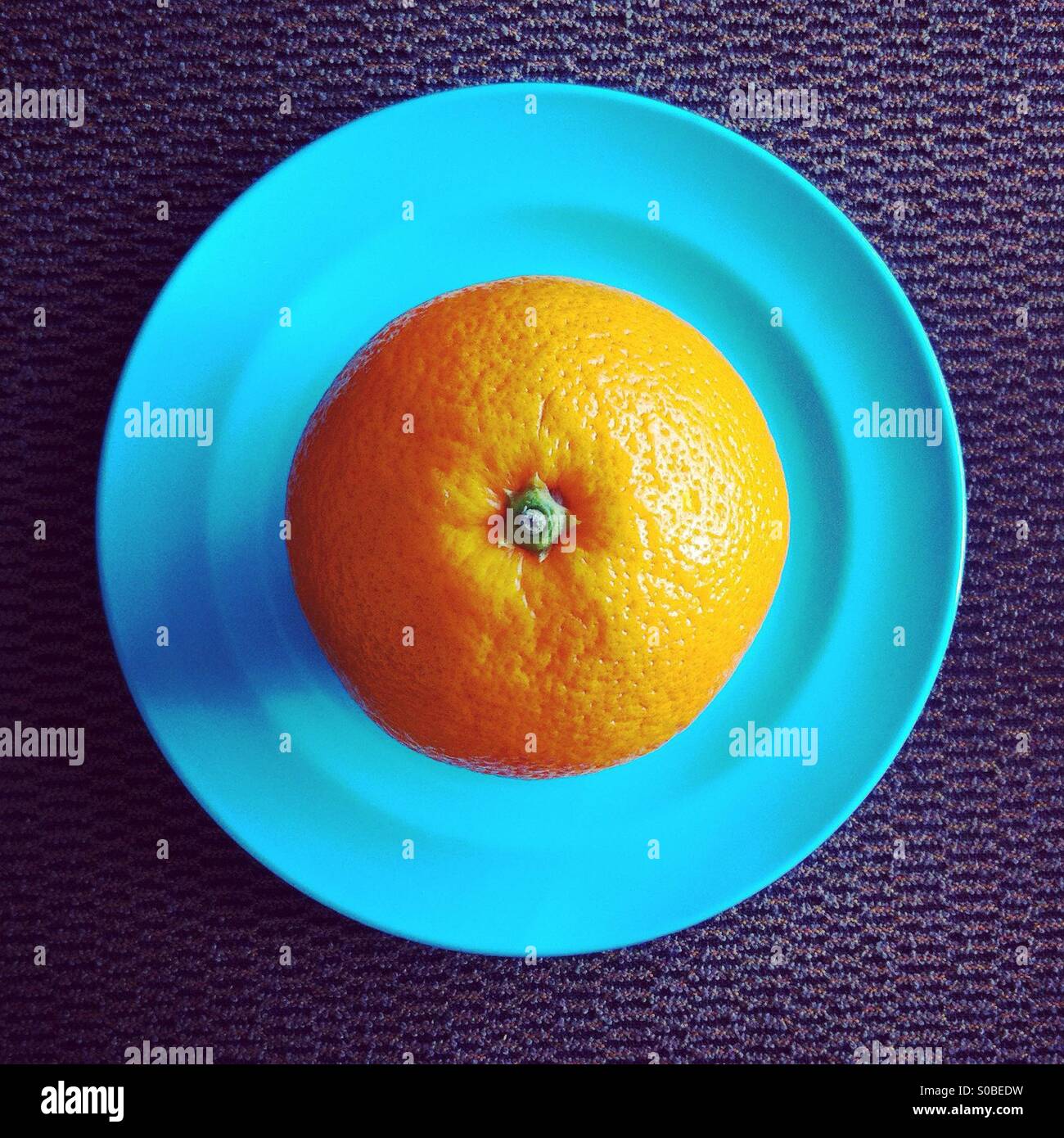 Draufsicht der orange Frucht in blaue Platte - Smartphone-aufgenommenes Stockfoto