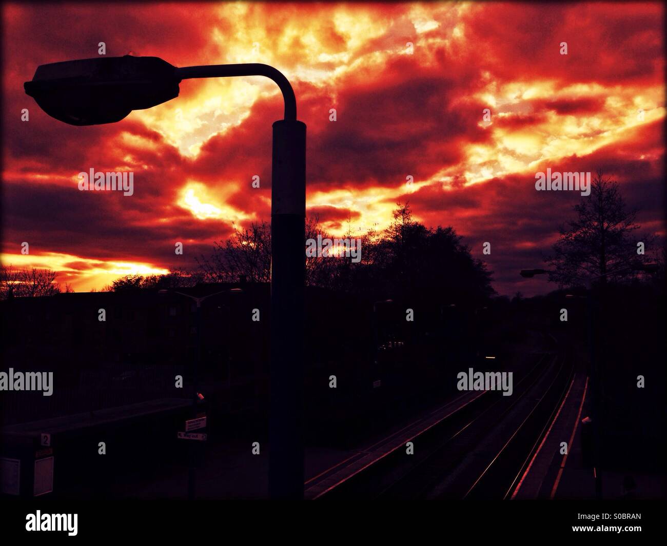 Blick auf Sonnenuntergang zeigt Lamp post und Bahnhof unten, Sudbury Hill Harrow Railway Station, London Borough of Harrow, London, England, Vereinigtes Königreich, Nordwesteuropa Stockfoto