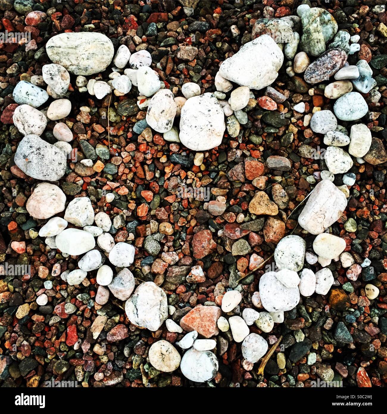 Ein weißes Herz aus Stein aus farbigen Kieselsteinen am Strand gemacht Stockfoto