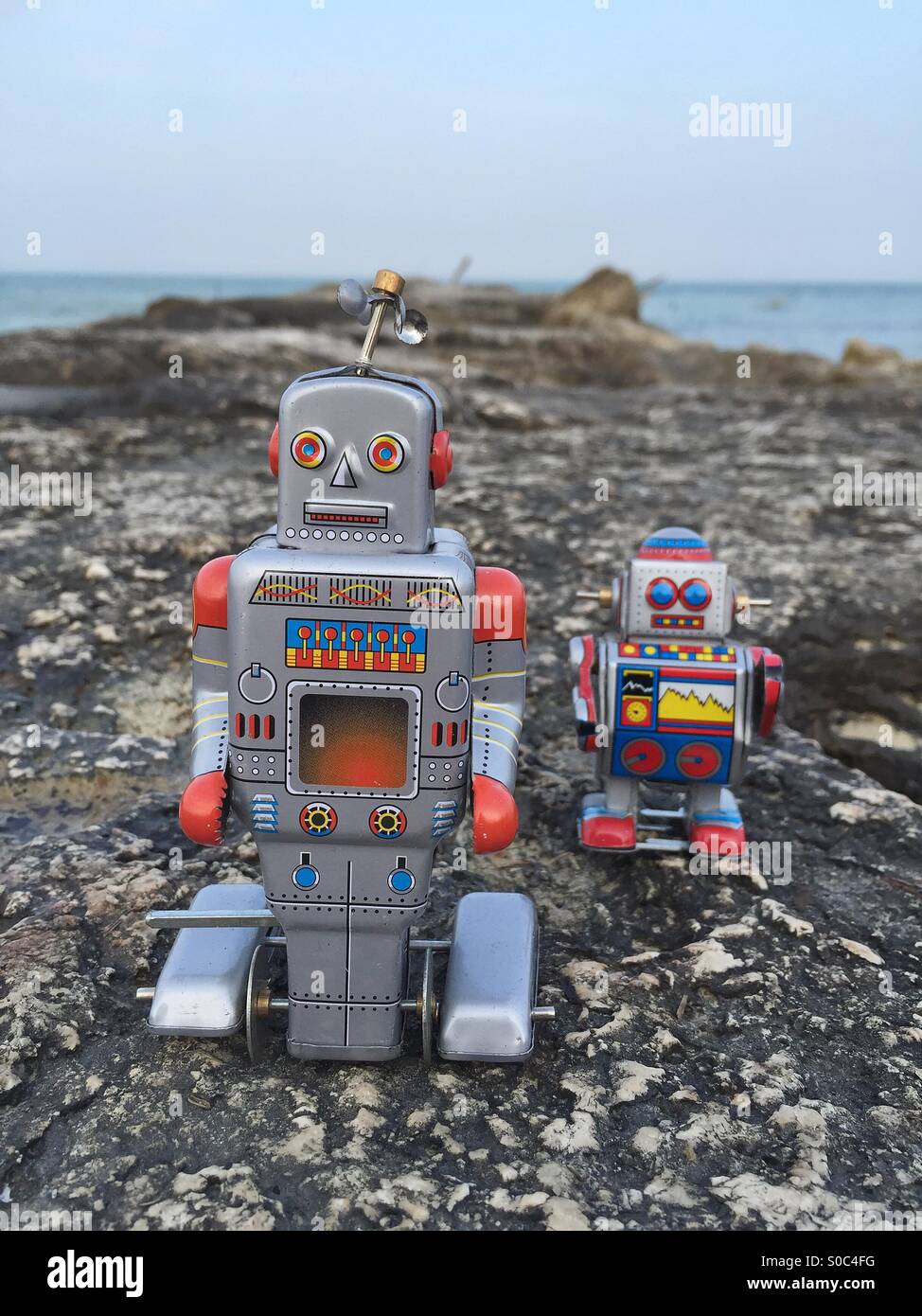 Zwei Blechspielzeug Roboter auf den Felsen Stockfoto