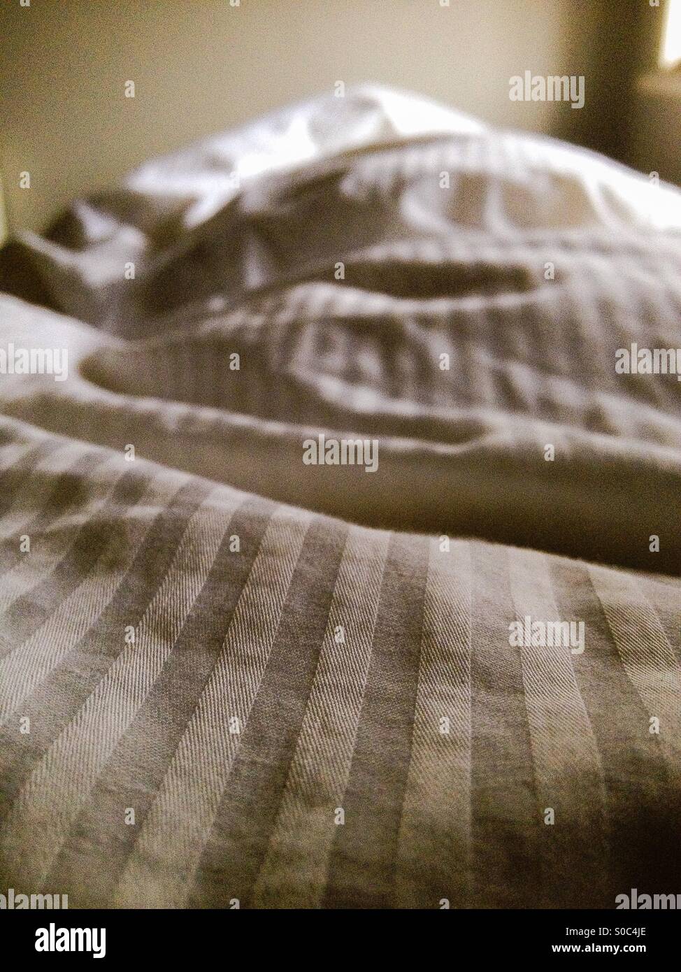 Gestreifte Bettbezug im Bett Stockfoto