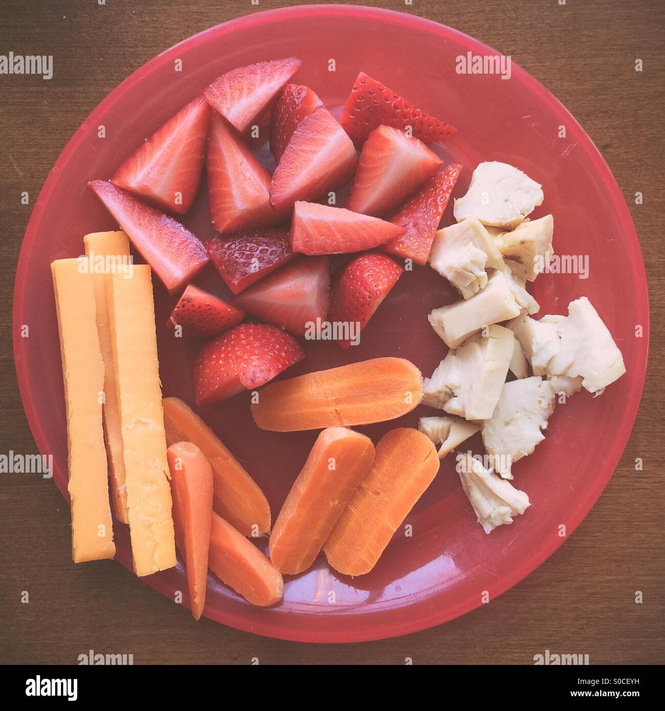 Gesundes Mittagessen für Kinder von Huhn, Karotten, Erdbeeren und Cheddar-Käse Stockfoto