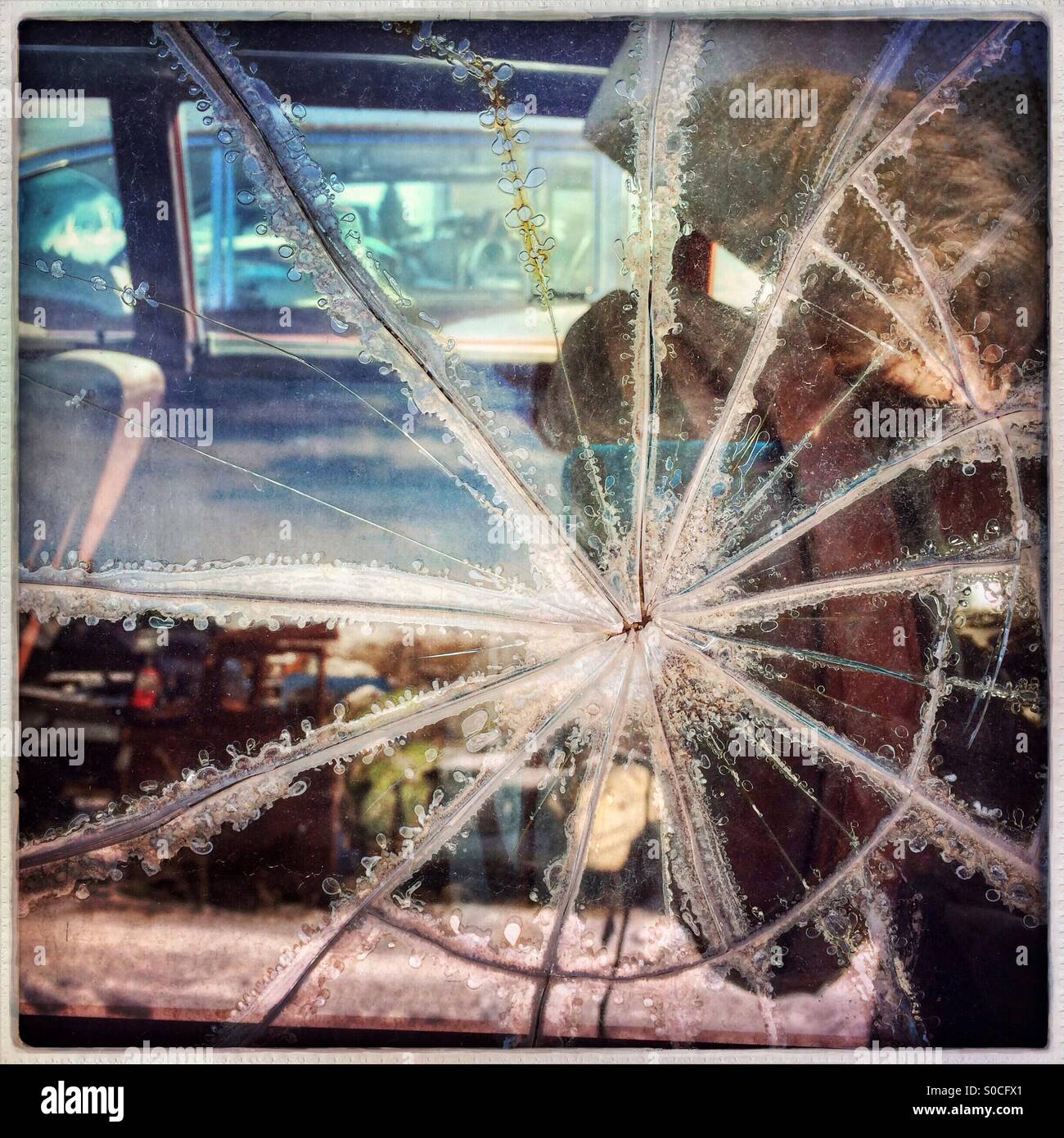 Starburst Muster in zerbrochene Fenster Glas auf ein altes Auto in einem Junk Yard. Stockfoto