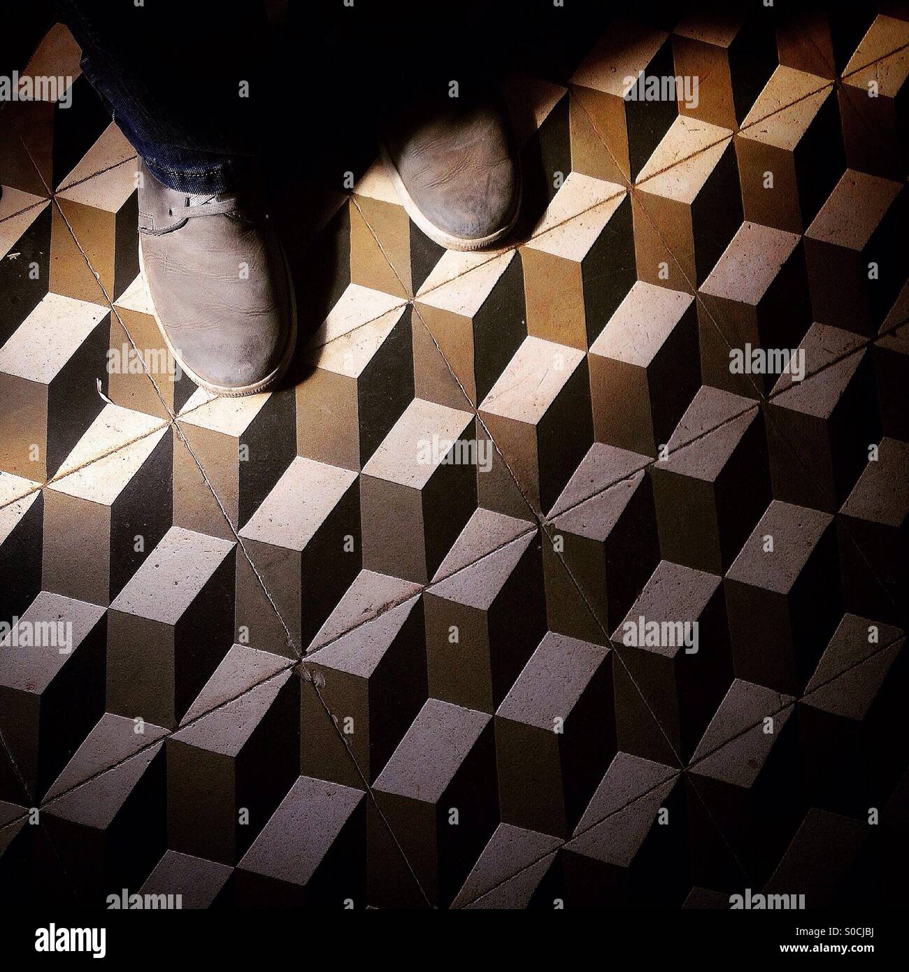 Ein Mann geht auf einer Etage, verziert mit geometrischen Figuren in einem Heim in Vila Ruiva, Portugal - Smartphone-aufgenommenes Stockfoto