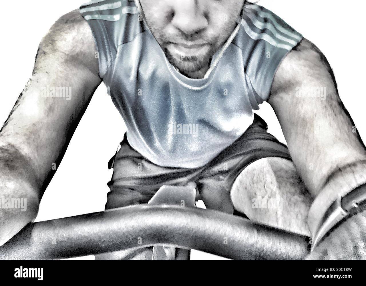 Ein Kerl in der Turnhalle auf einem stationären Fahrrad Stockfoto