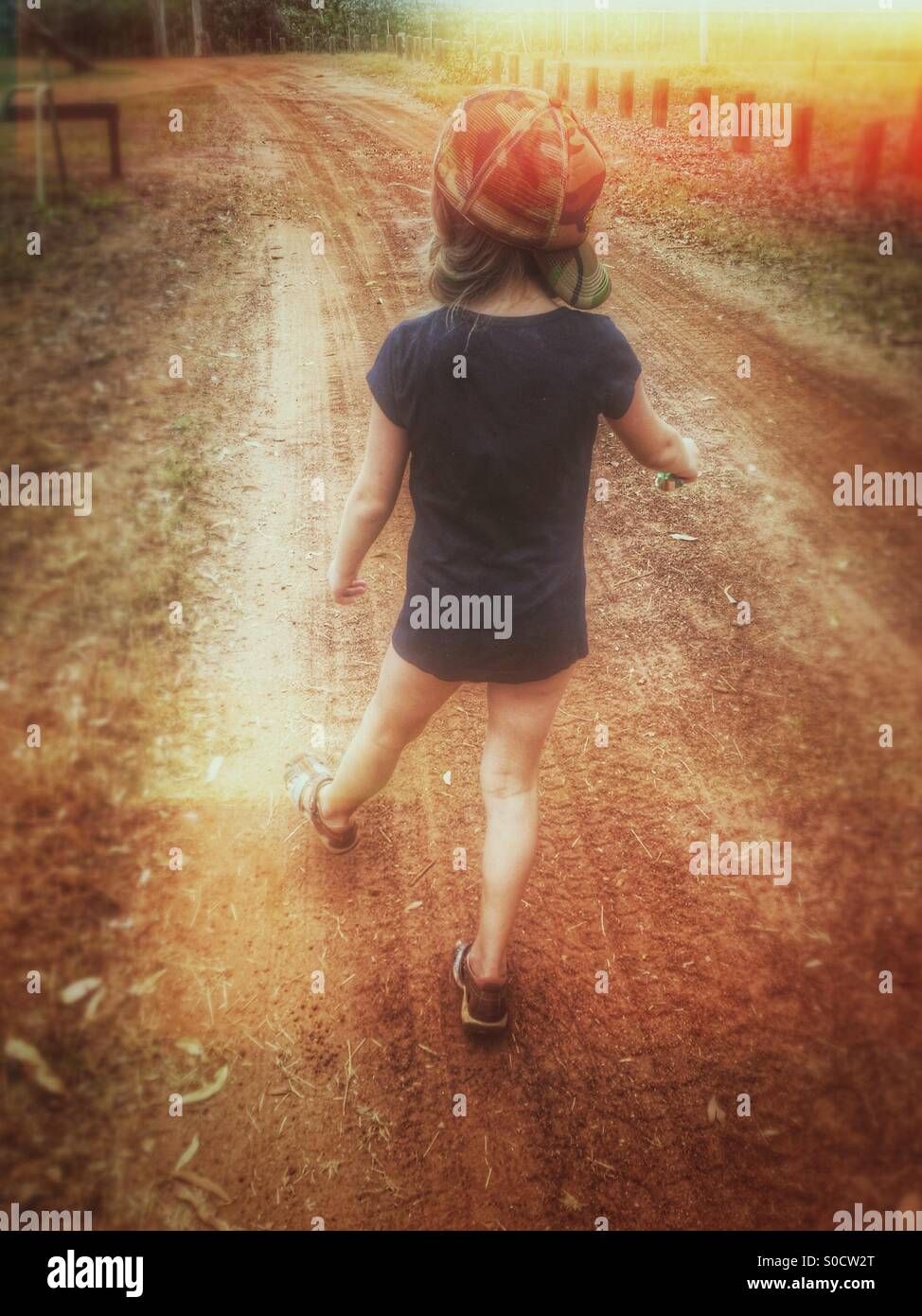 Kleines Mädchen zu Fuß auf einem Feldweg im australischen Outback. Stockfoto