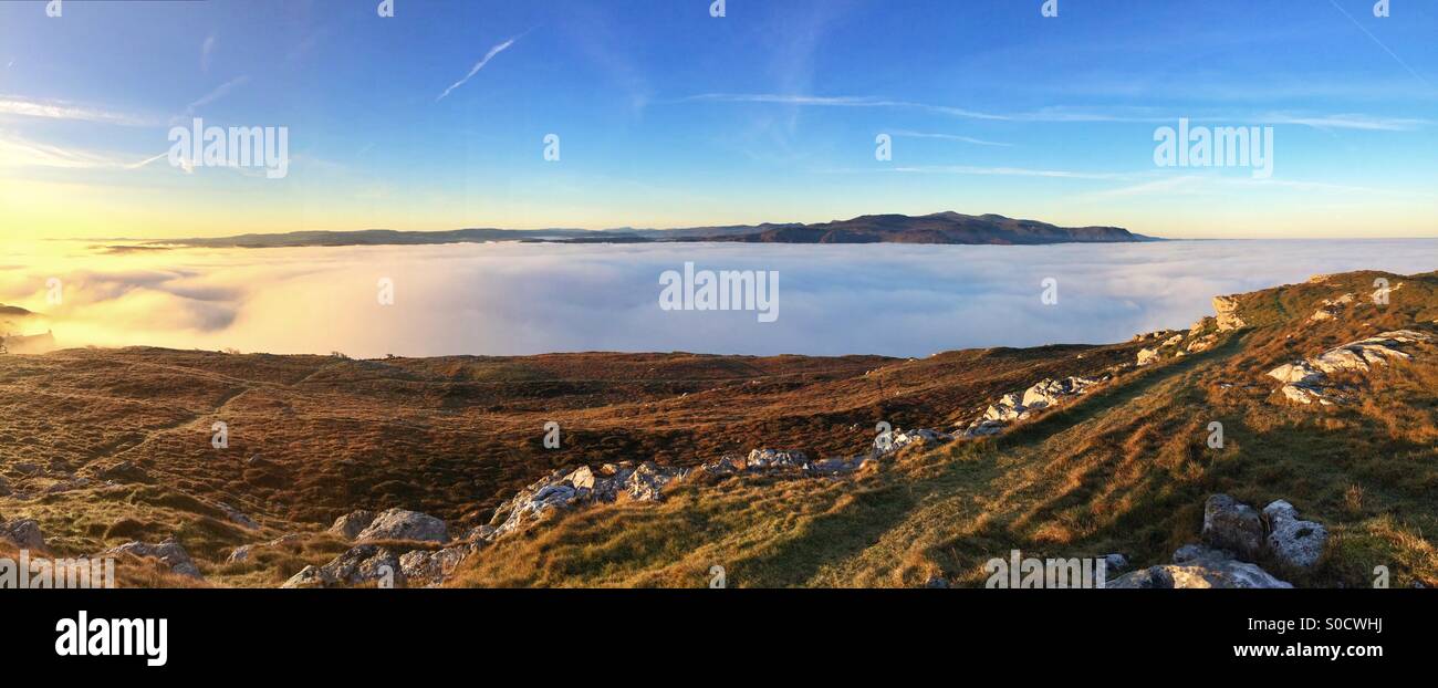 Sonnenaufgang über den Great Orme, Llandudno und der Snowdonia Bergkette Wales mit erstaunlichen Meer Nebel. Stockfoto