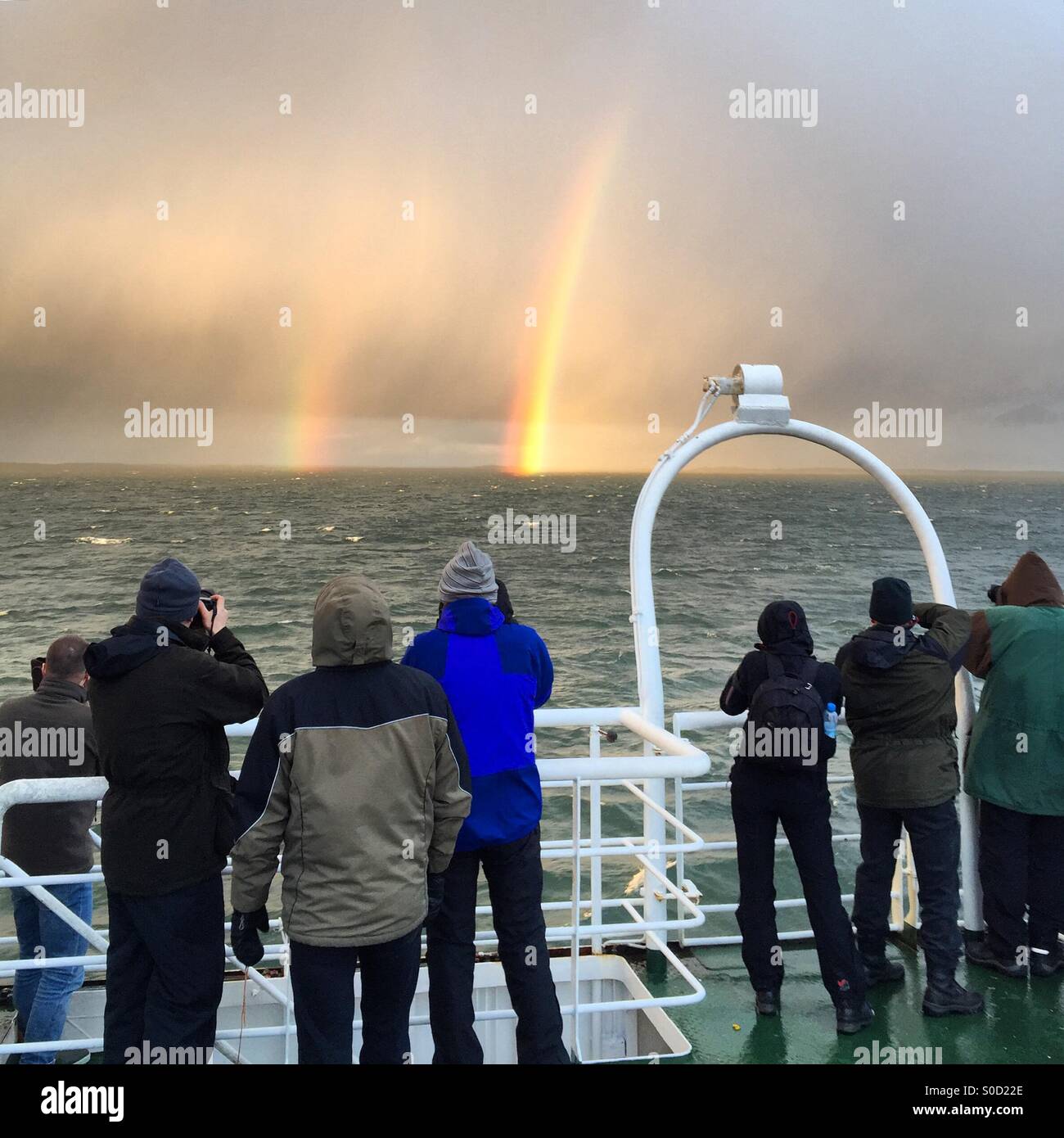 Touristen auf einem Ostsee Abenteuer Kreuzfahrt Foto eine dramatische doppelter Regenbogen während eines Sturms in den entfernten Finnland Schären Stockfoto