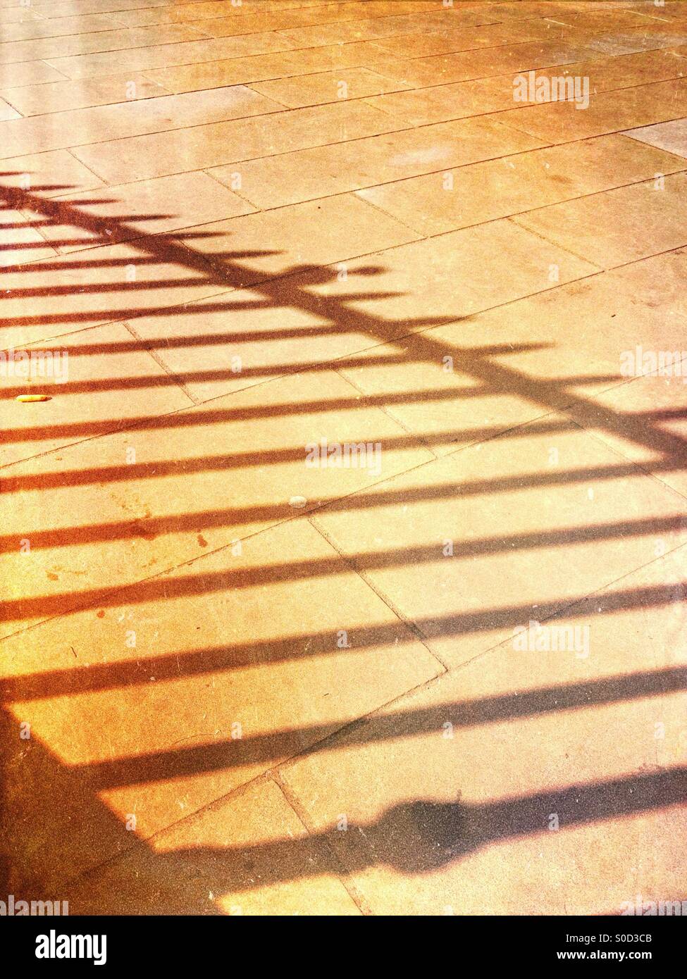 Schatten der Geländer auf Bürgersteig Stockfoto