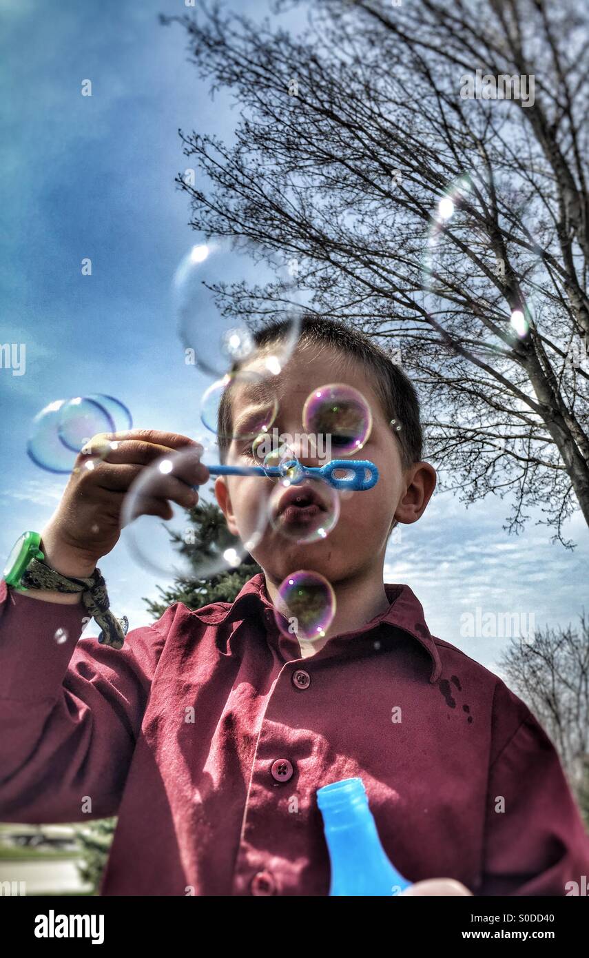 Kleiner Junge bläst Luftblasen in einer iPhone-Kamera Stockfoto