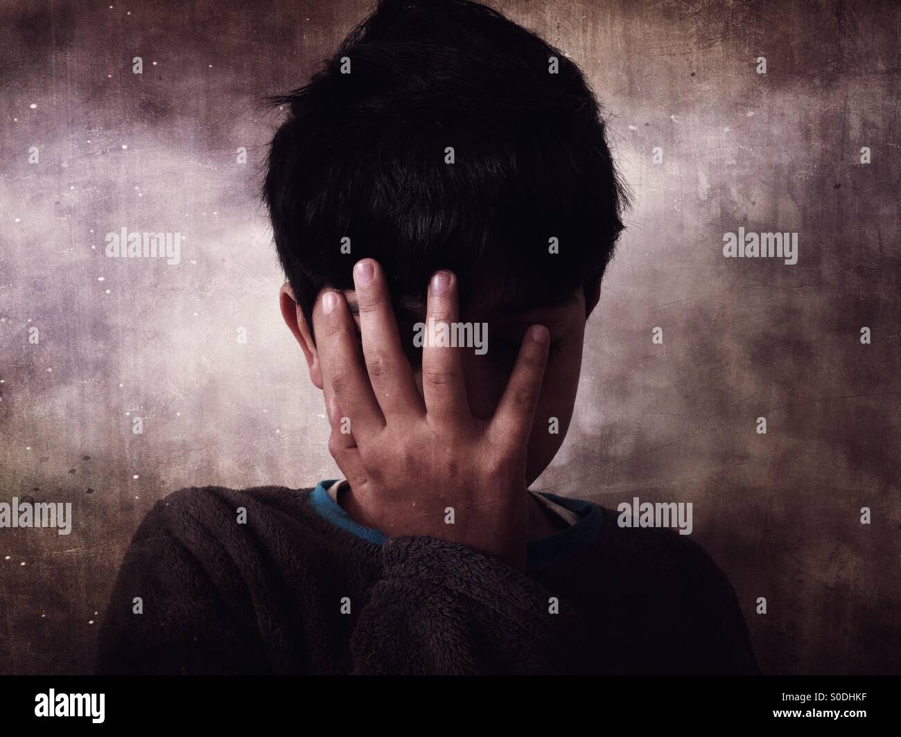 Elende junge Gesicht mit der Hand versteckt Stockfoto