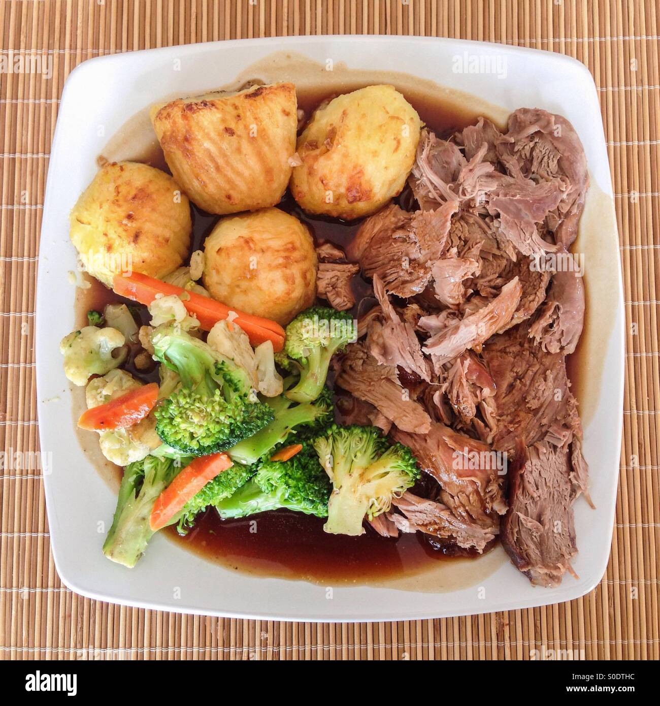 Lammbraten und Bratkartoffeln mit Gemüse und Soße. Mittagessen am Sonntag. - Smartphone-aufgenommenes Stockfoto