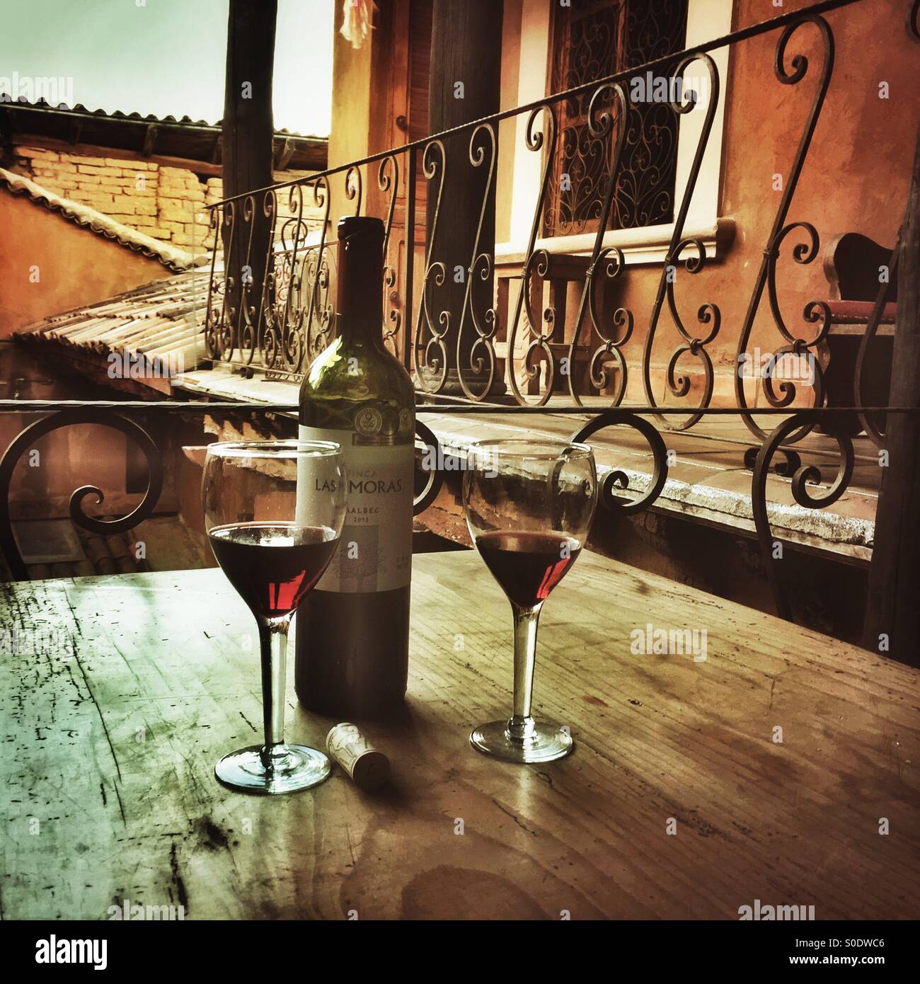 Wein wird serviert auf einem rustikalen Tisch in einer gemütlichen Nische in einem charmanten Bed &amp; Breakfast in Patzcuaro, Michoacan. Stockfoto