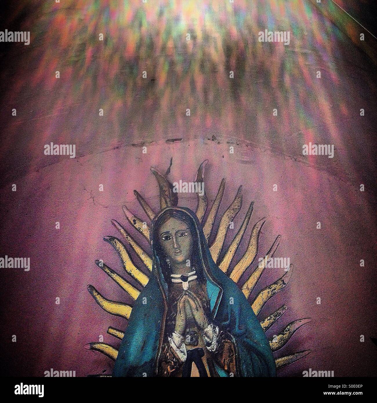 Sonnenstrahlen über ein Bild der Muttergottes von Guadalupe in Colonia Condesa, Mexiko-Stadt, Mexiko - Smartphone-aufgenommenes Stockfoto