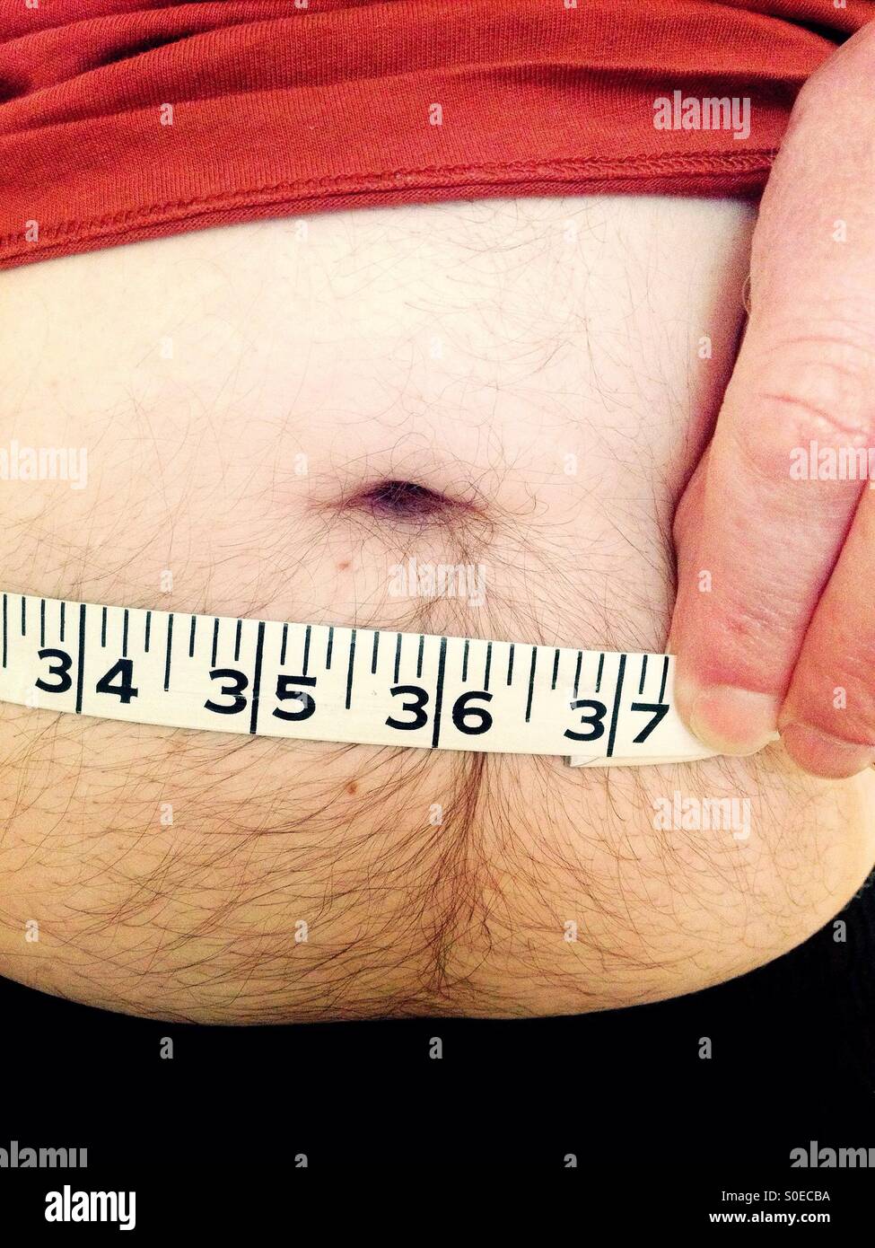 Mann seine Taille messen Stockfoto