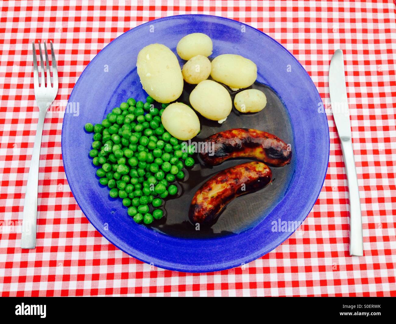 Neue Kartoffeln, Würstchen, Erbsen und Soße. - Smartphone-aufgenommenes Stockfoto