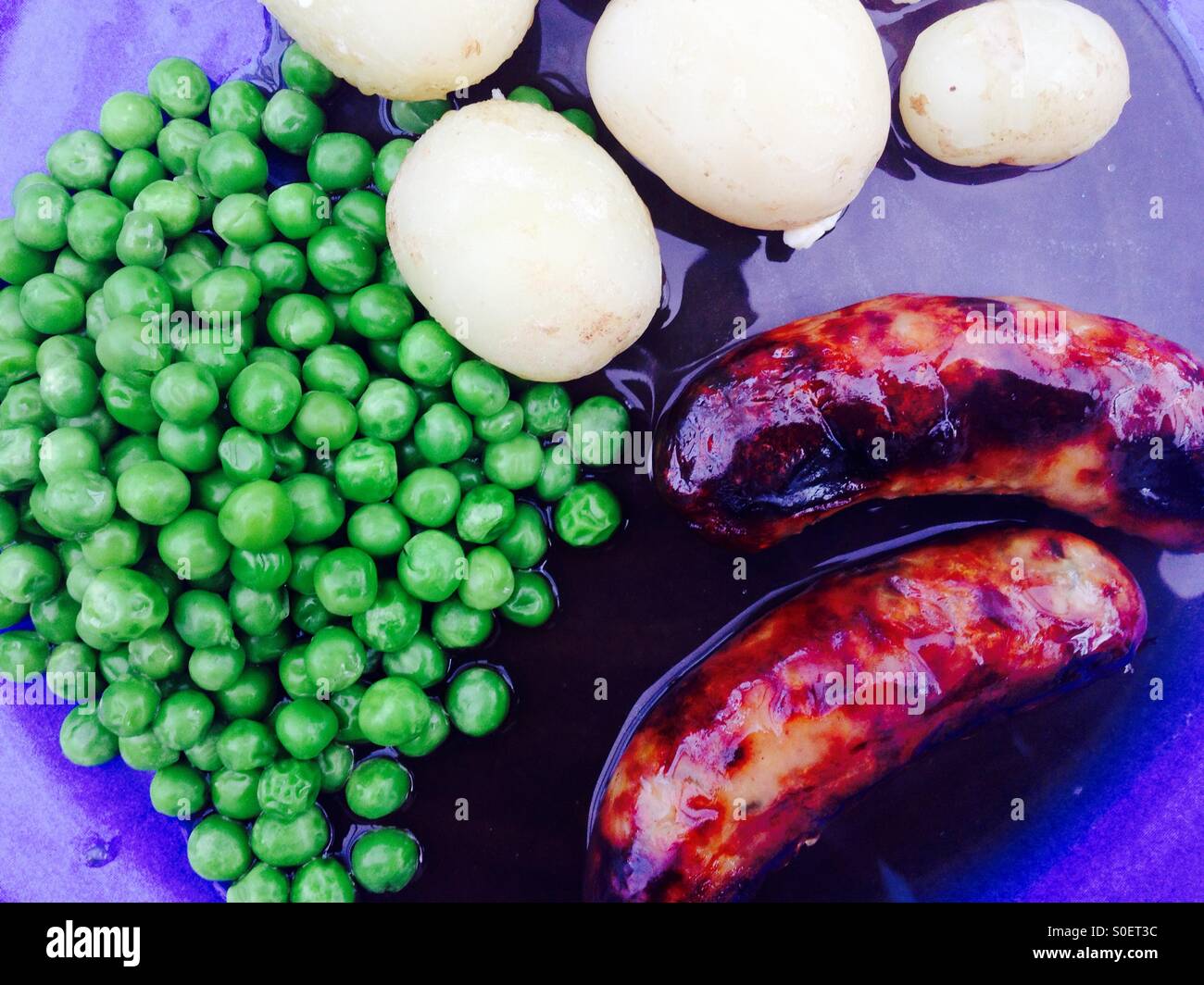 Würstchen, neuen Kartoffeln, Erbsen und Soße - Smartphone-aufgenommenes Stockfoto