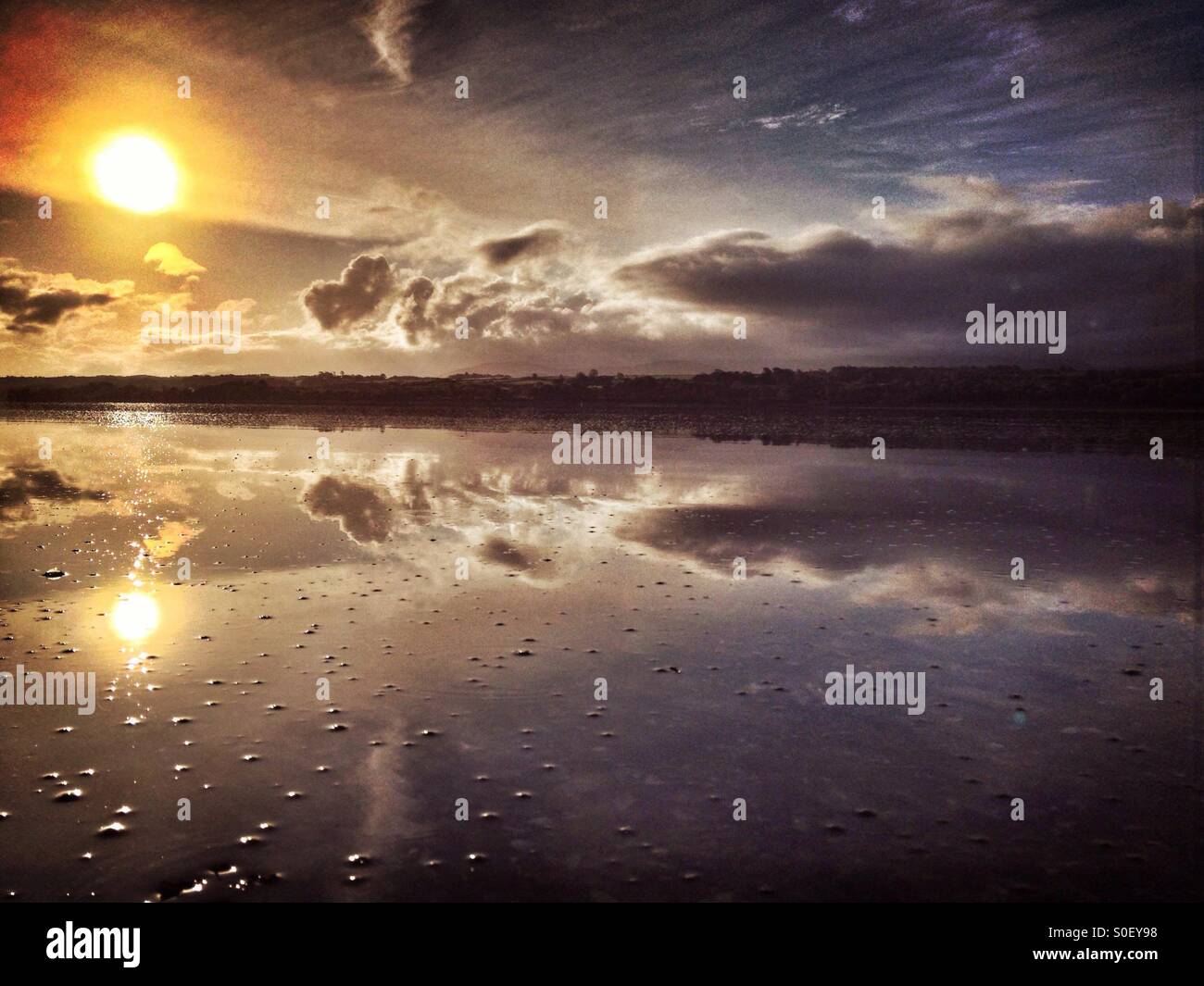 Reflexion des frühen Morgensonne und Wolken im Menai Strait von Anglesey Stockfoto