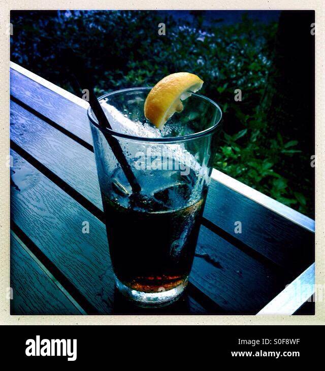 Cola-Getränk mit Zitrone auf Tisch - Smartphone-aufgenommenes Stockfoto