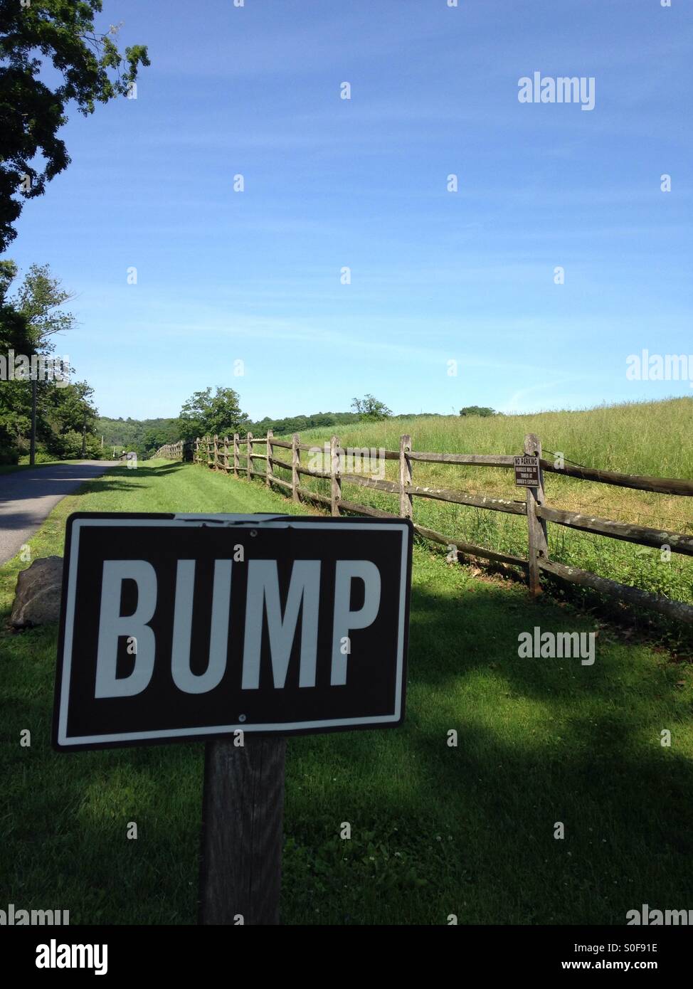 Ein Schild kündigt "Bump", auf der Seite einen Feldweg. Stockfoto