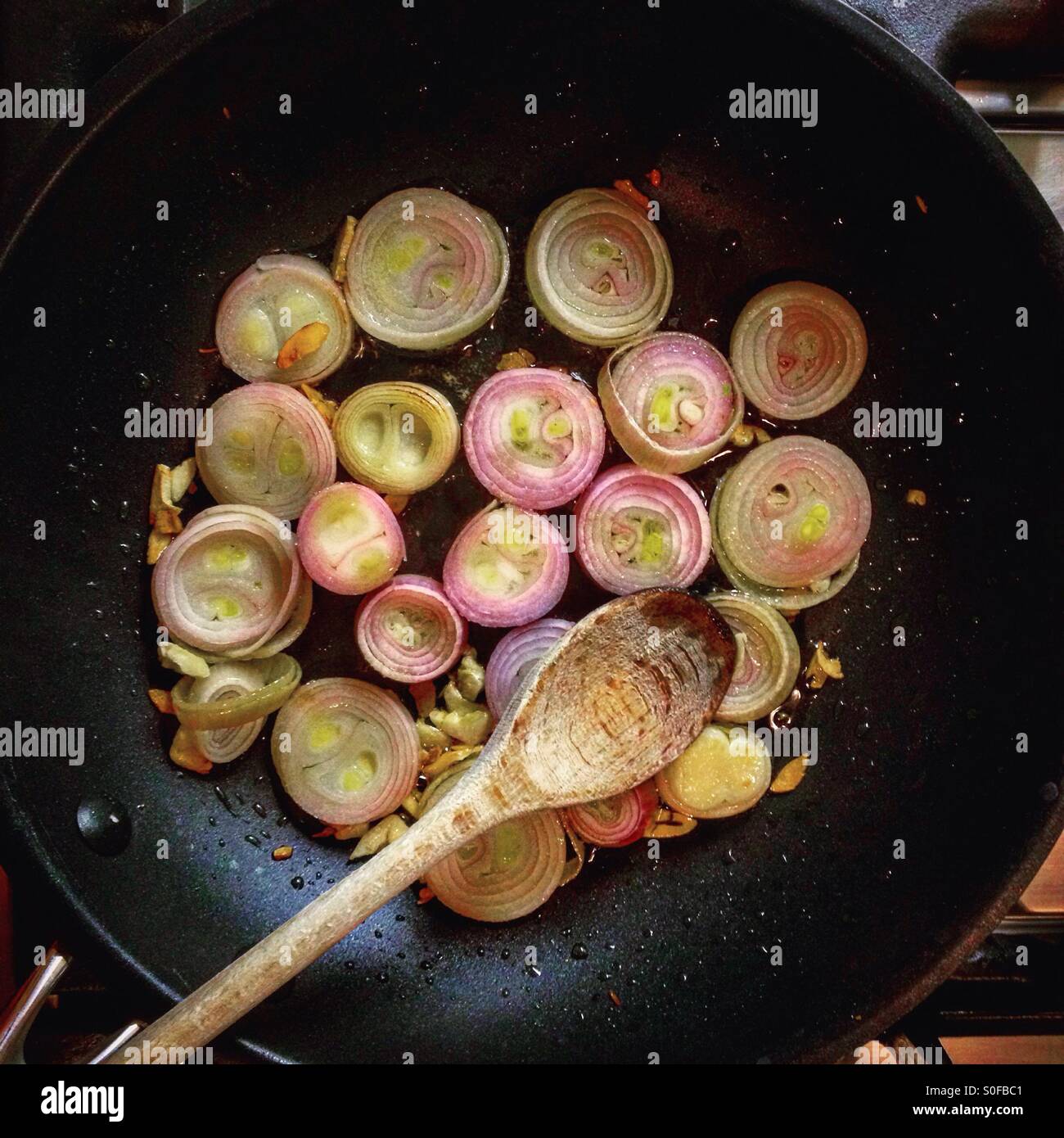 Schalotten und Knoblauch in einer Pfanne braten Stockfoto