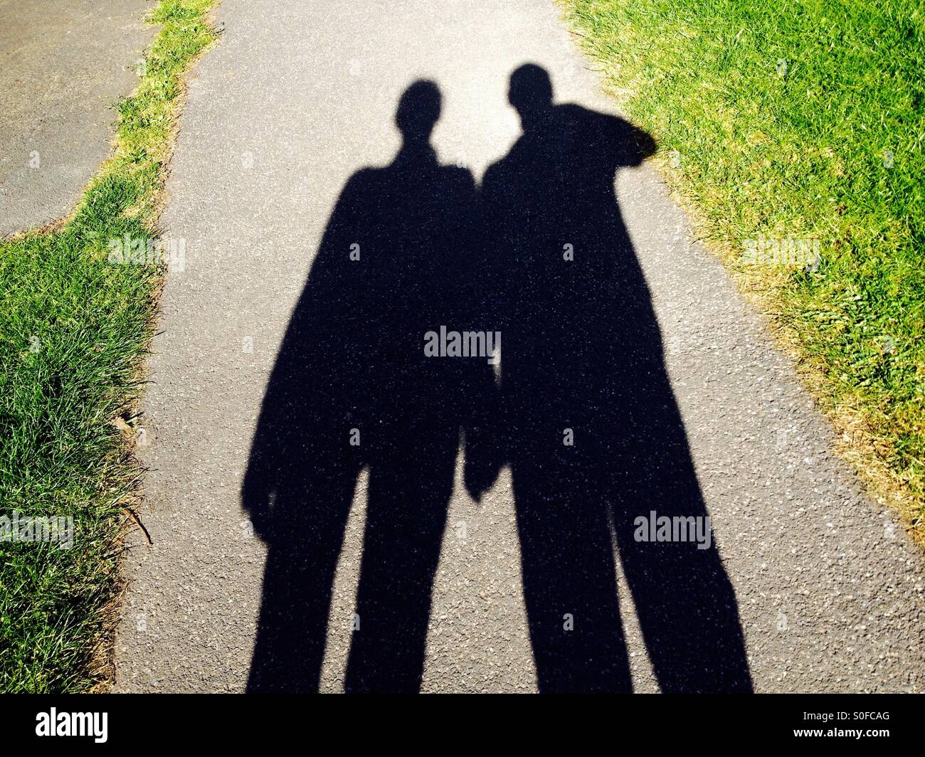 Schatten der männlichen und weiblichen Spaziergang im park - Smartphone-aufgenommenes Stockfoto