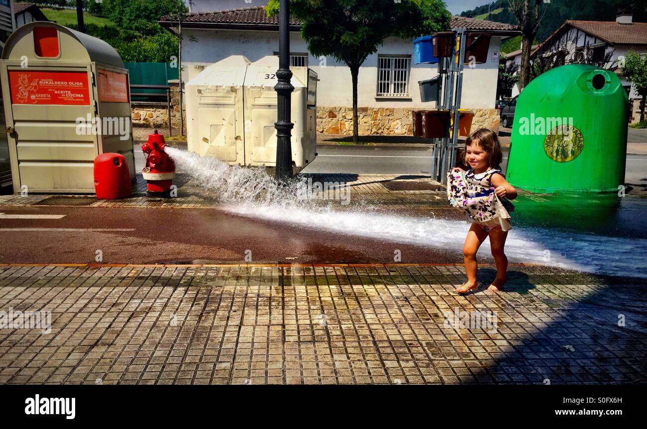3-jähriges Mädchen Spaß vor einem Hydranten in Nordspanien Stockfoto