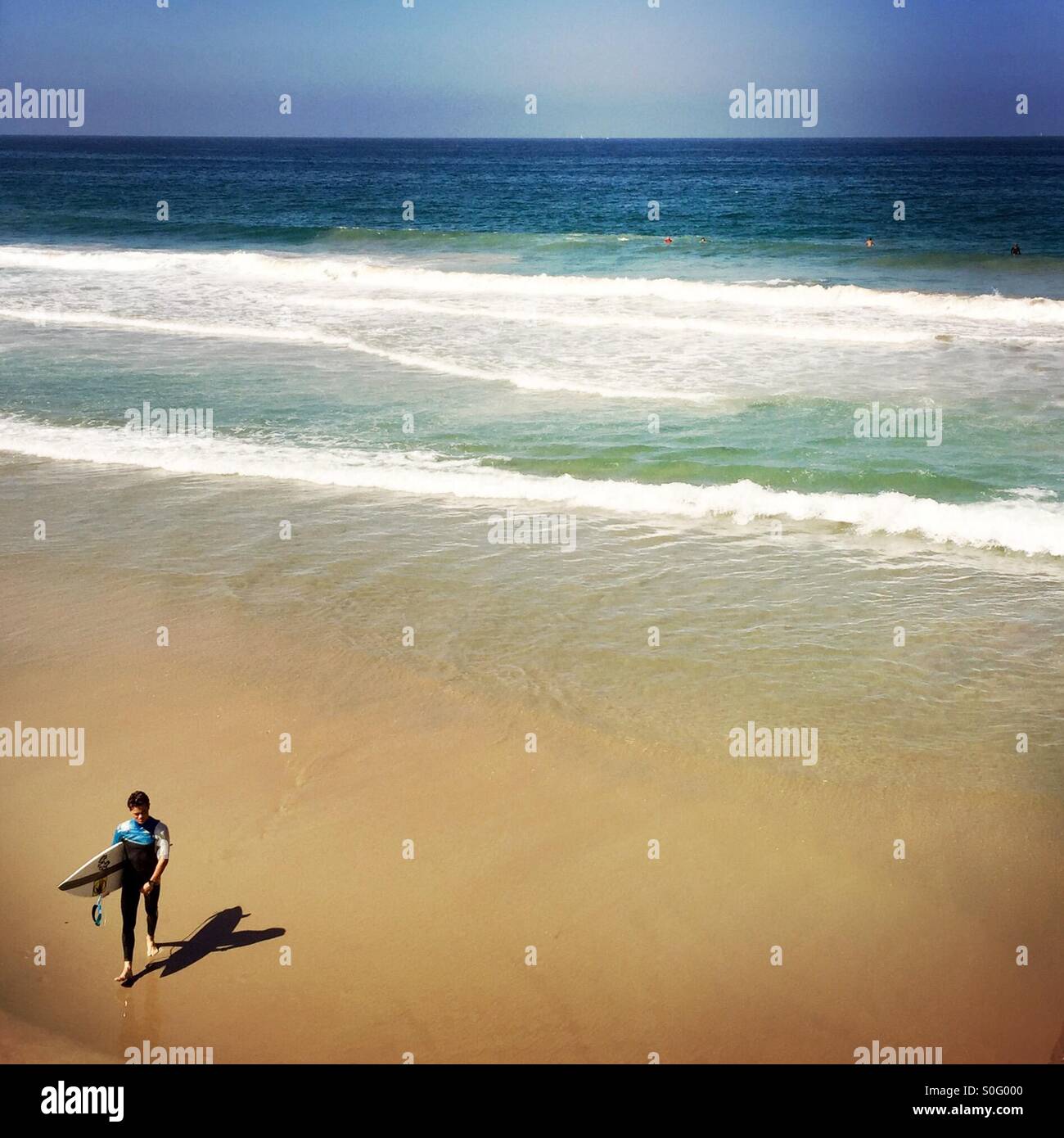 Eine männliche Surfer geht bis zum Strand. Manhattan Beach, Kalifornien. USA. Stockfoto