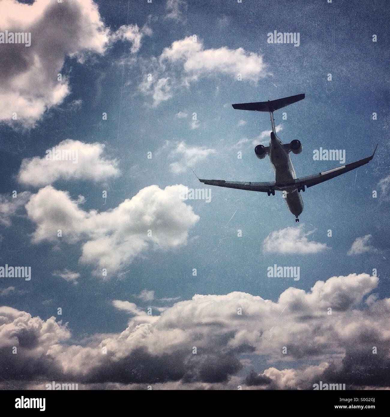 Flugzeug fliegen overhead gegen blauen Wolkenhimmel Stockfoto