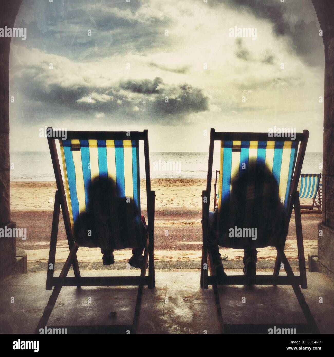 Relaxen in Liegestühlen am Strand von Bournemouth Stockfoto