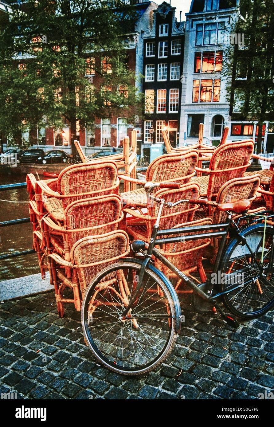 Gestapelten Stühle und ein Fahrrad auf einer Brücke in Amsterdam Niederlande EU - Smartphone-aufgenommenes Stockfoto