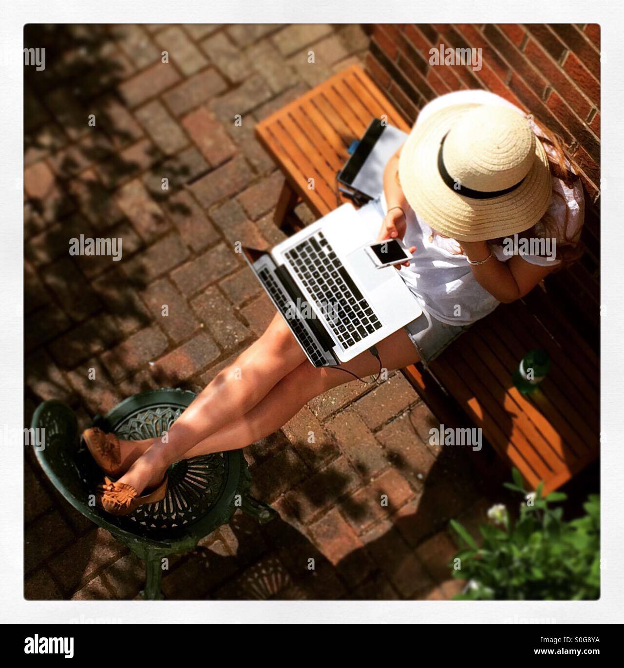 Weiblich, die Arbeiten am Laptop draußen im Sommer von oben gesehen Stockfoto