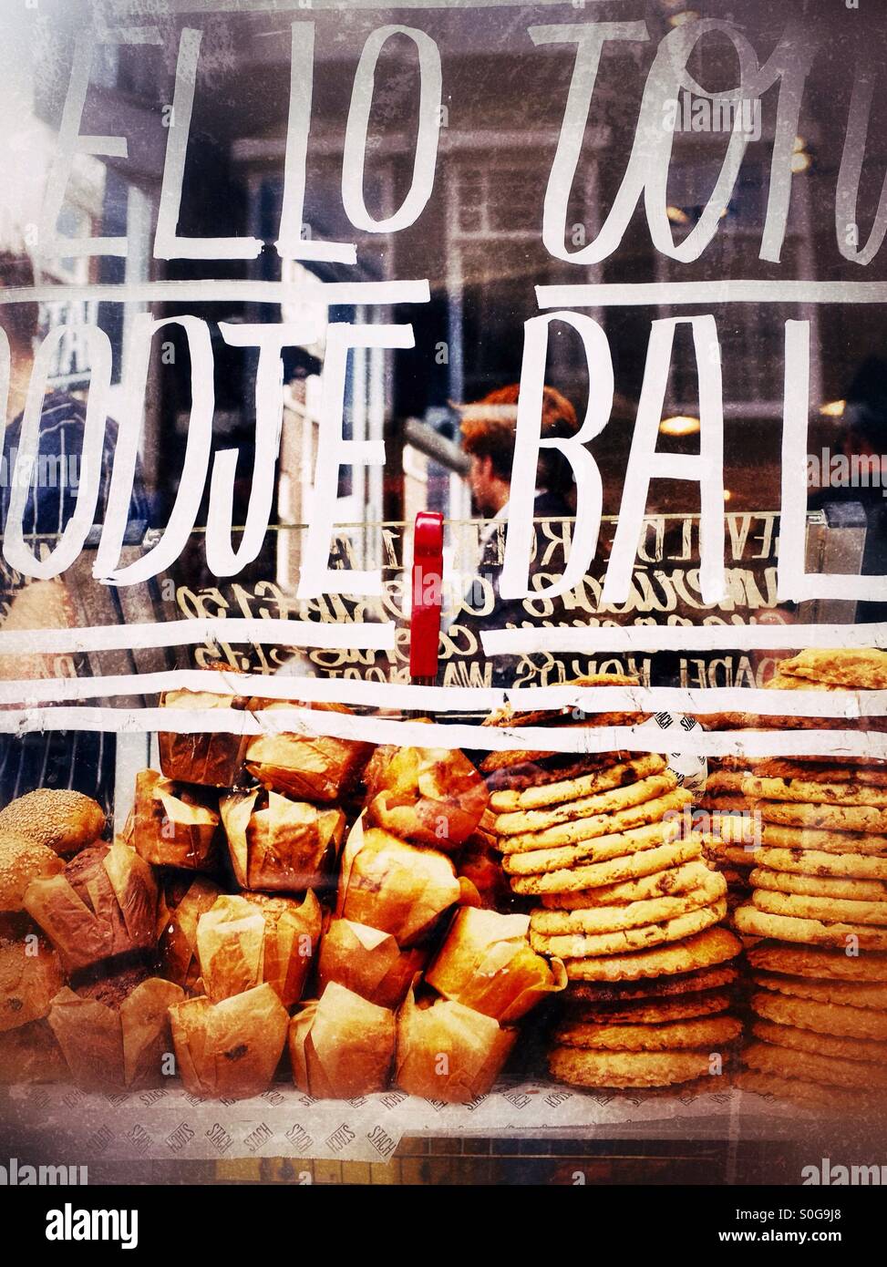 Ein Bäckerei-Fenster vollgestopft mit Muffins und cookies - Smartphone-aufgenommenes Stockfoto