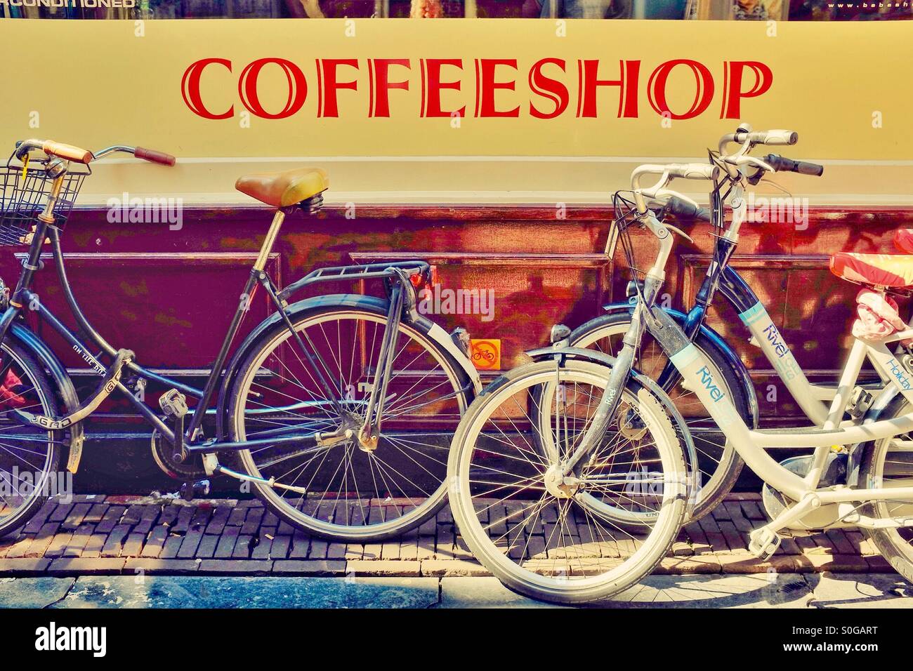 Fahrräder parken außerhalb ein Coffeeshop Amsterdam in den Niederlanden EU - Smartphone-aufgenommenes Stockfoto