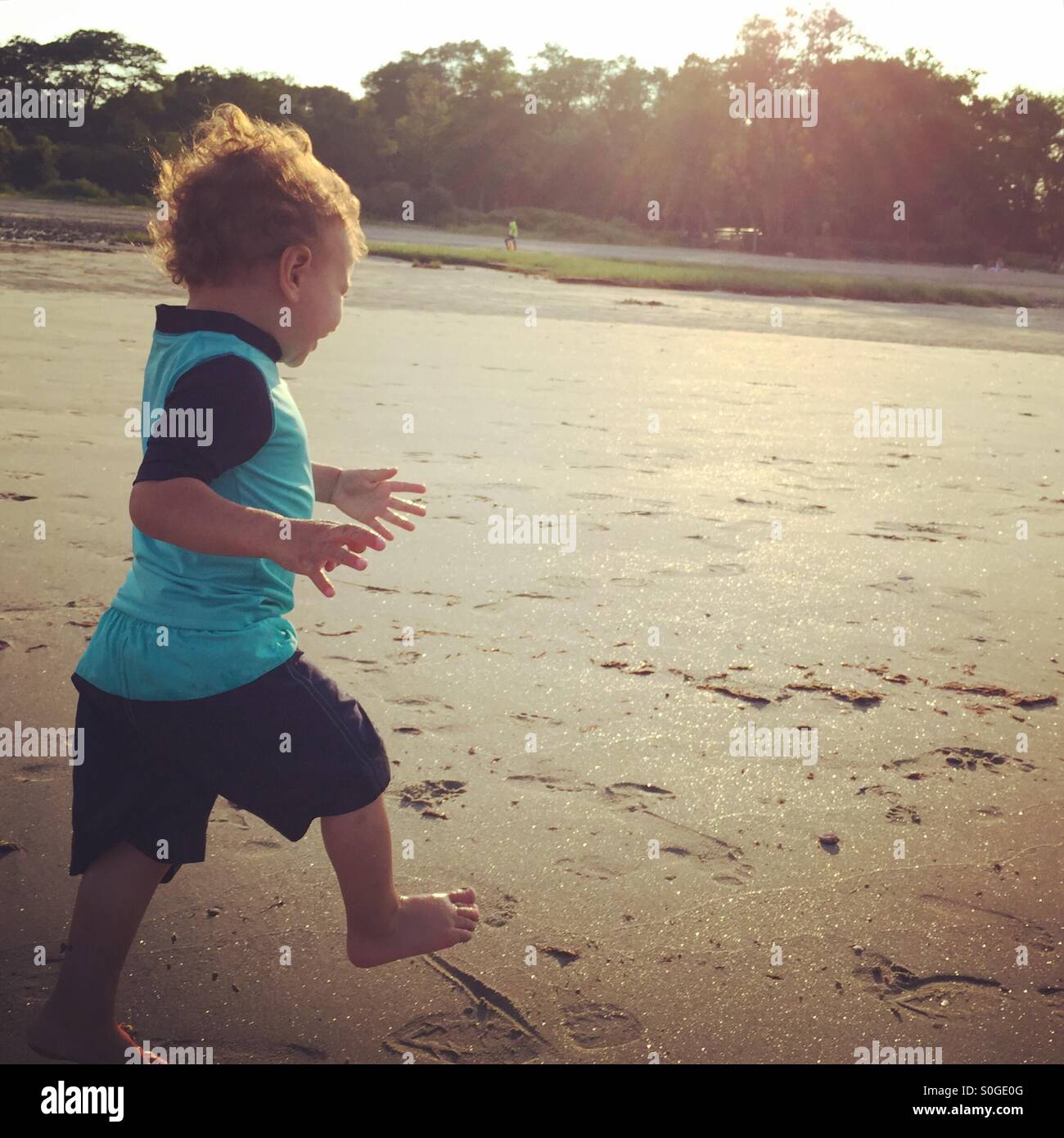 Kleinkind laufen am Strand Stockfoto